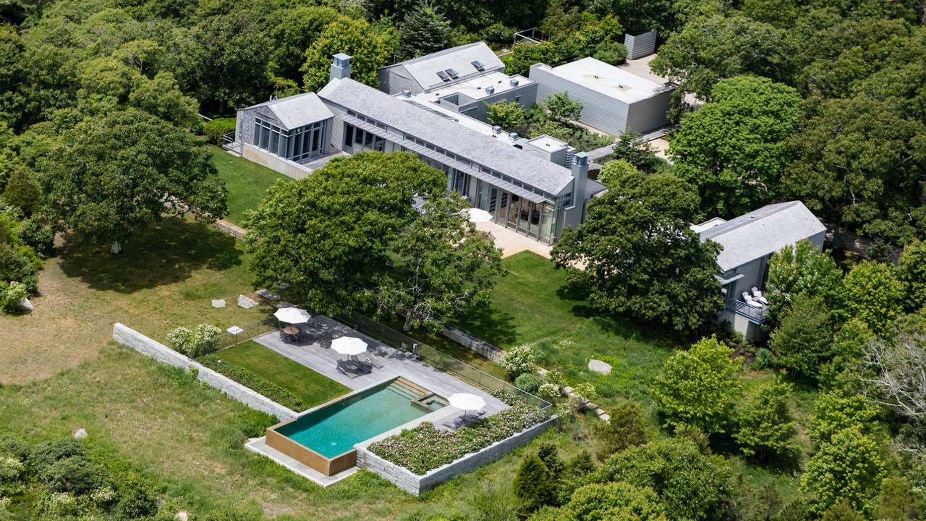 On the grounds, there's an infinity-edge swimming pool, a two-bedroom guesthouse, an outdoor kitchen and a basketball court.