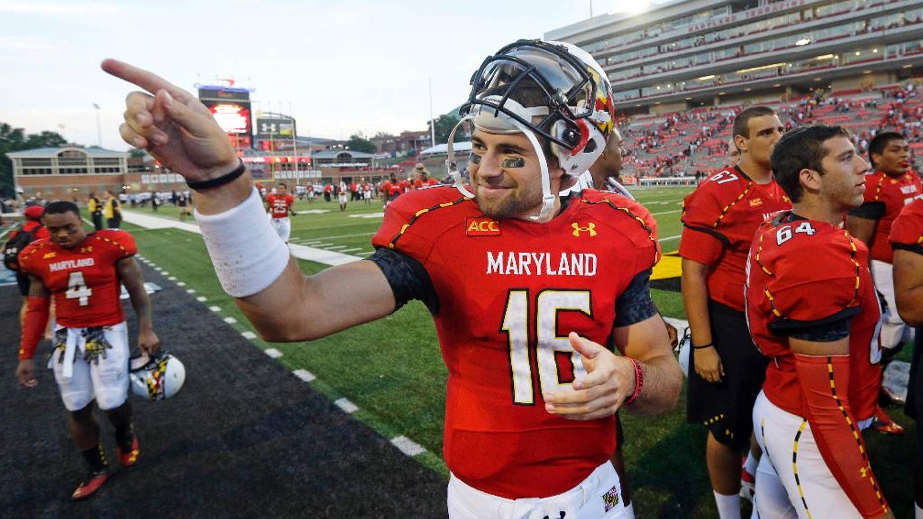 FILE - In this Sept. 7, 2013, file photo, Maryland quarterback C.J. Brown acknowledges fans in the stands after an NCAA college football game against Old Dominion in College Park, Md. Now in his sixth year at Maryland, Brown just might have attended more classes and taken more snaps than any other quarterback in the country. (AP Photo/Patrick Semansky, File)