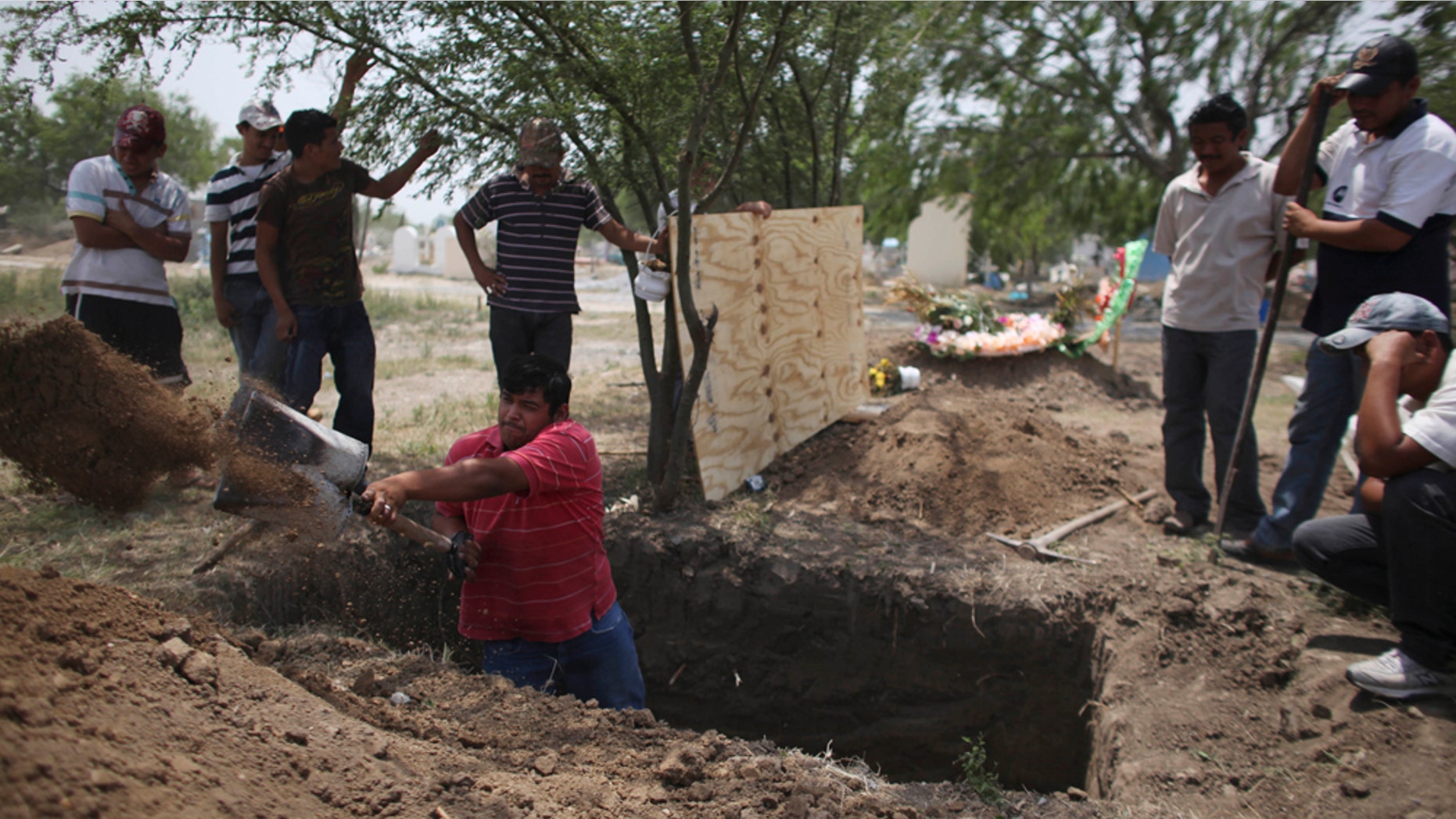 In this photo taken April 27, 2011, family members of Alfredo Espinosa, allegedly killed by unknown assailants, dig a grave at a local cemetery in San Fernando, Mexico. A total of 183 bodies have been found in mass graves near San Fernando, most of them were presumably people kidnapped from buses traveling between Ciudad Victoria and the border town of Matamoros, according to authorities. (AP Photo/Alexandre Meneghini)