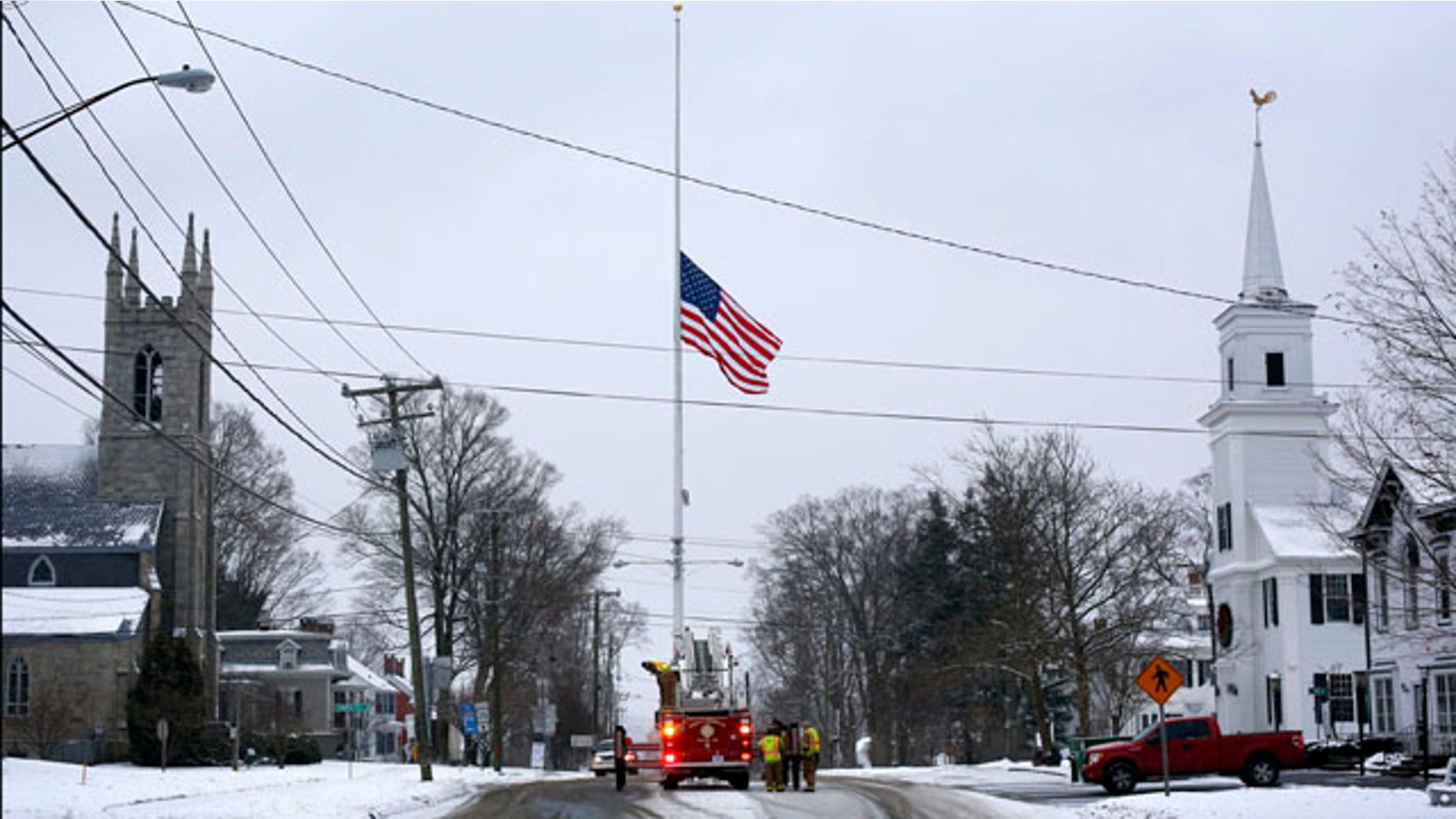 December 14, 2013: On the first anniversary of the Sandy Hook massacre, firefighters in Newtown, Conn. lower the town's flag on Main Street to half-staff in honor of the victims. (AP Photo/Robert F. Bukaty, File)