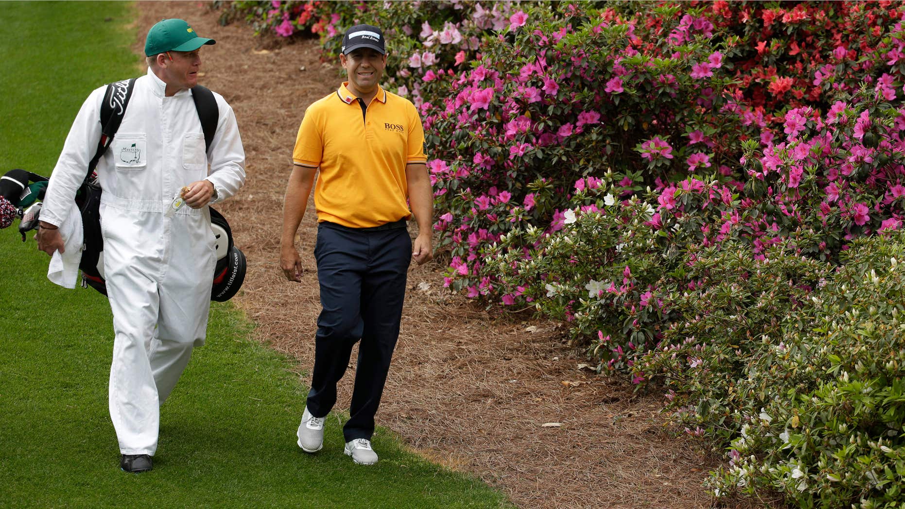 April 6, 2015: Erik Compton walks with his caddie down the sixth fairway during a practice round for the Masters golf tournament.