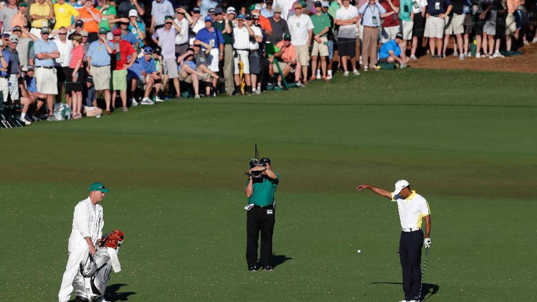 FILE - In this April 12, 2013 file photo, Tiger Woods takes a drop on the 15th hole after his ball went into the water during the second round of the Masters golf tournament in Augusta, Ga. Players as well as the rule officials come from all around the world to the Masters, making the official rulings as discussed as the score. (AP Photo/Charlie Riedel, File)