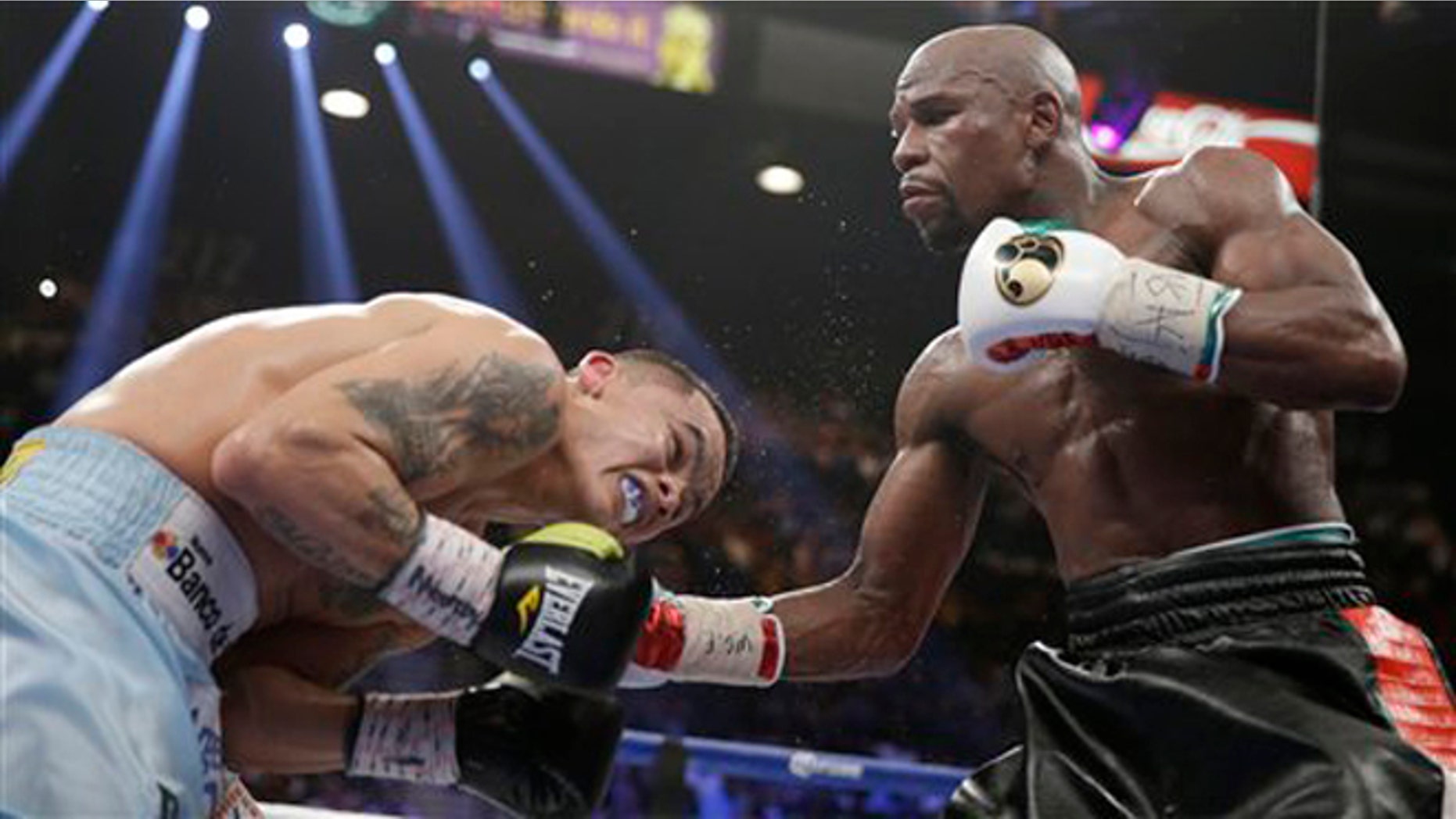 Floyd Mayweather Jr., right, connects with a right to the head of Marcos Maidana, from Argentina, in their WBC-WBA welterweight title boxing fight Saturday, May 3, 2014, in Las Vegas. (AP Photo/Isaac Brekken)