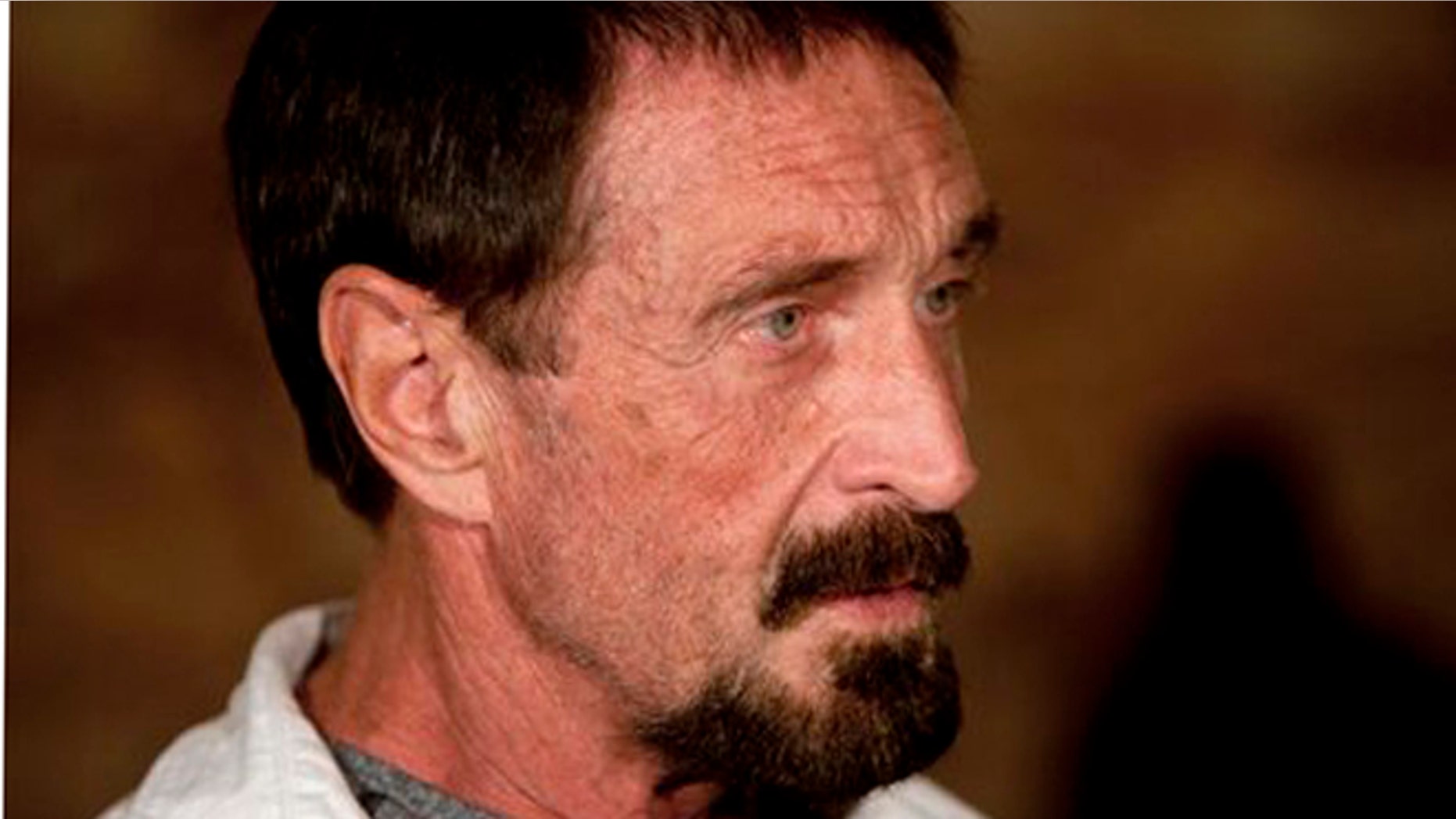 Software company founder John McAfee listens to a question during an interview at a local restaurant in Guatemala City, Tuesday, Dec. 4, 2012. McAfee, 67, has been identified as a "person of interest" in the killing of his neighbor in Belize, 52-year-old Gregory Faull. Police are urging McAfee to come in for questioning. The anti-virus company founder fled Belize and is seeking political asylum in Guatemala, according to his lawyer Telesforo Guerra. (AP Photo/Moises Castillo)