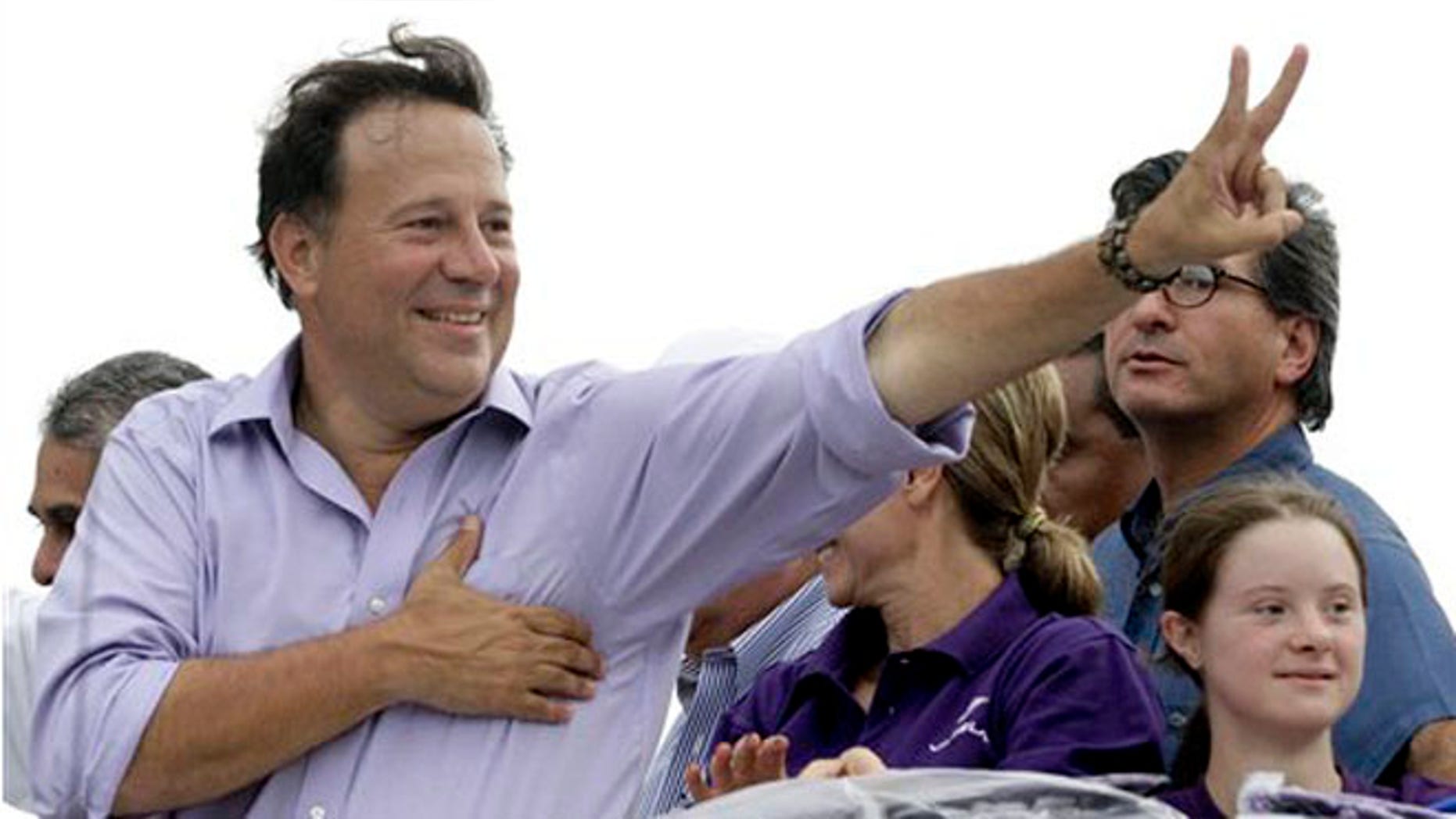 FILE- In this April 25, 2014 file photo, Juan Carlos Varela, presidential candidate for the Panamenista Party, waves to supporters during a campaign caravan through Arraijan on the outskirts of Panama City. Varela owes a debt of gratitude to a former adviser to John McCainâs ill-fated 2008 White House run for his come from behind victory in Panamaâs presidential election. (AP Photo/Arnulfo Franco, File)