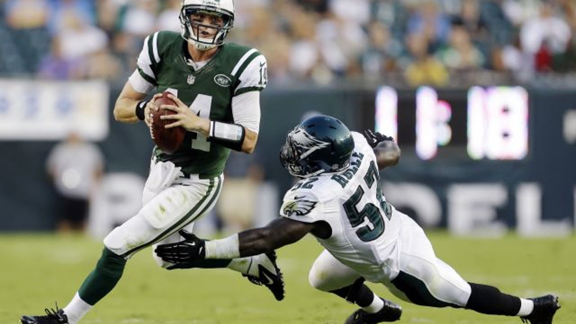 New York Jets quarterback Greg McElroy, left, scrambles away from Philadelphia Eagles linebacker Brian Rolle in the first half of a preseason NFL football game, Thursday, Aug. 30, 2012, in Philadelphia. (AP Photo/Matt Rourke)