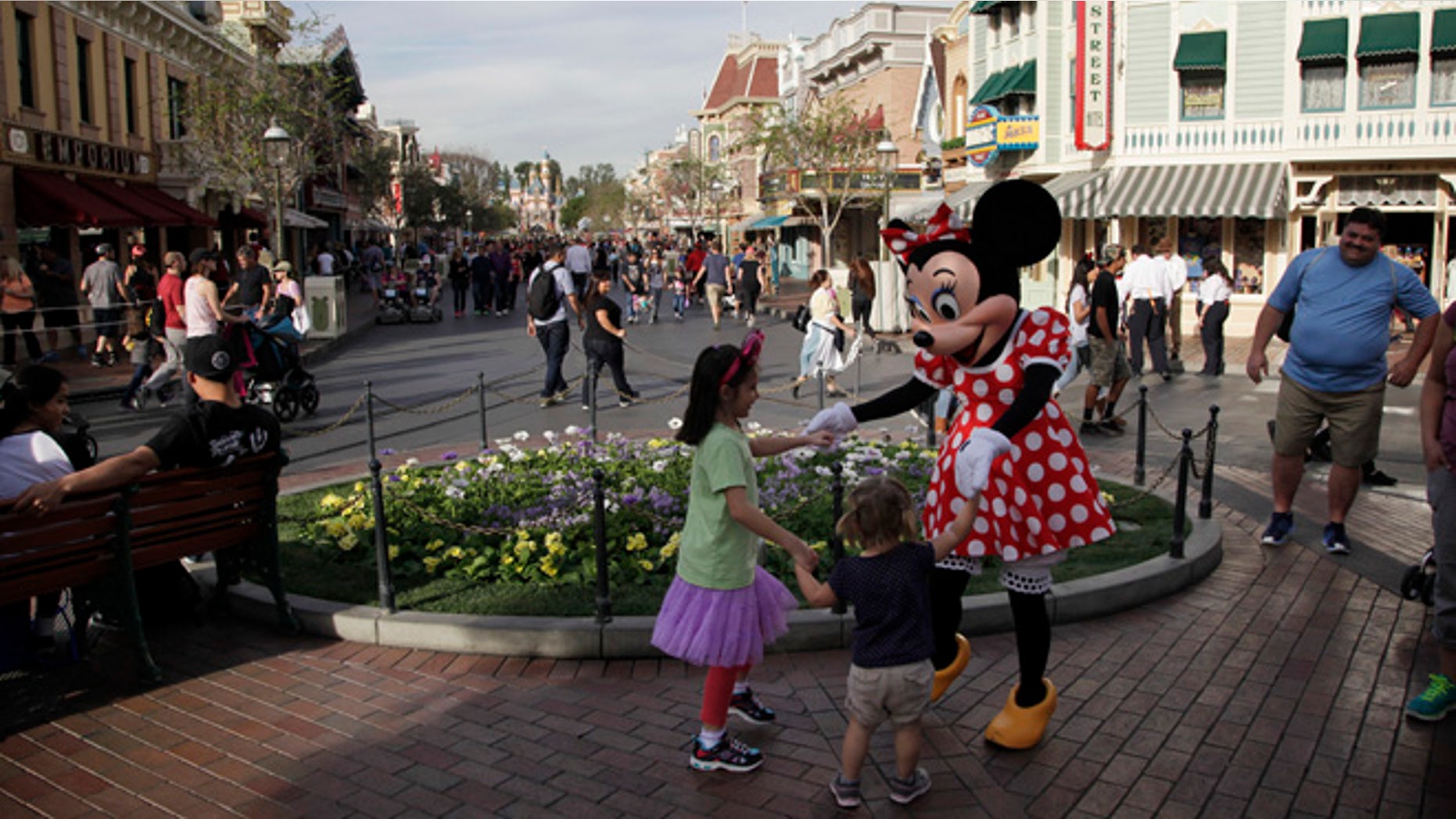 Minnie Mouse dances with visitors at Disneyland, Thursday, Jan. 22, 2015, in Anaheim, Calif. A major measles outbreak traced to Disneyland has brought criticism down on the small but vocal movement among parents to opt out of vaccinations for their children. (AP Photo/Jae C. Hong)