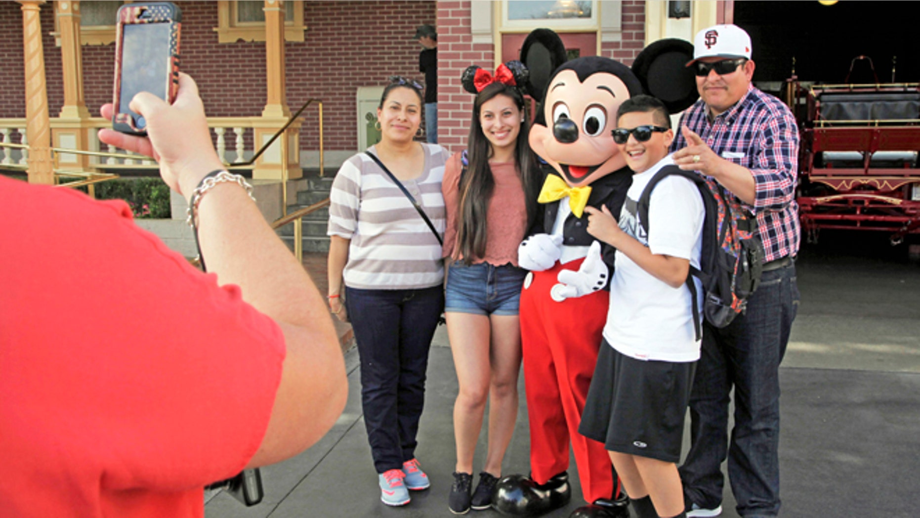 Visitors pose with Mickey Mouse at Disneyland in Anaheim, Calif.