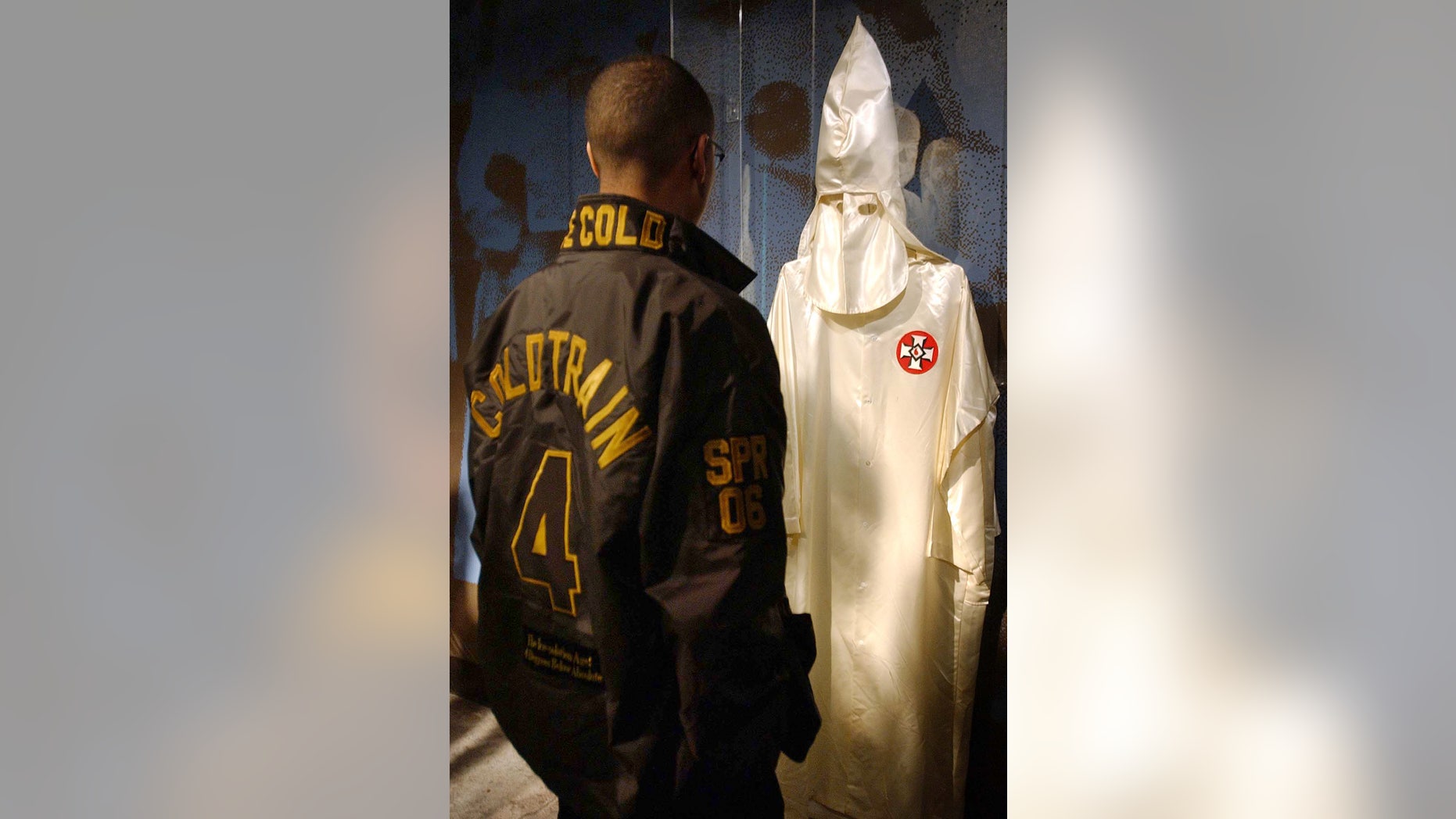 FILE - In this Sunday, Jan. 28, 2007 file photo, Emmanuel Gunn looks at a Ku Klux Klan robe and hood on display at the Birmingham Civil Rights Institute during the final stop of an exhibit on the Freedom Ride in Birmingham, Ala. A group from Nashville re-traced the historic civil rights journey from Montgomery, Ala., to Birmingham during the weekend trip. The Freedom Riders started as a small group of 15 volunteers in 1961, but they swelled to a movement of more than 400 during their protests in Alabama, Mississippi and Georgia over that year. The black and white volunteers sat together on buses, trains and planes, and staged sit-ins at segregated restaurants, lunch counters and hotels. (AP Photo/Michelle Williams)