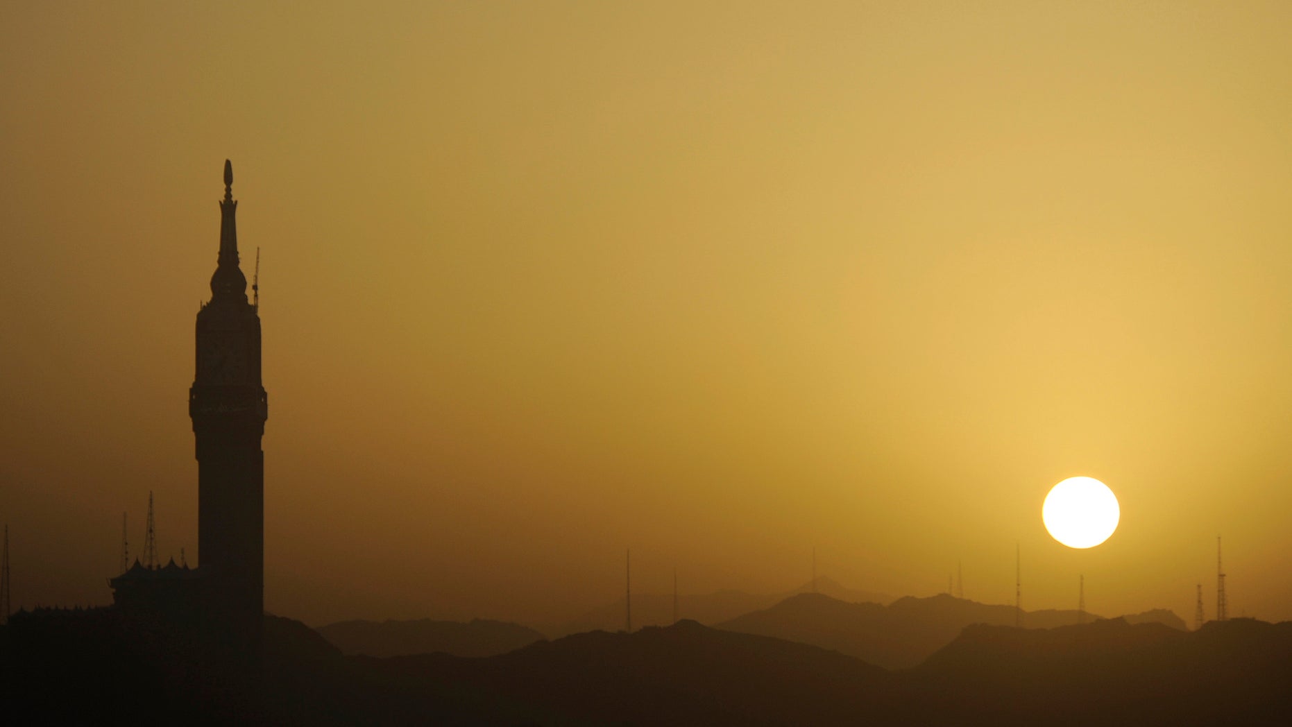 The sun rises next to the Mecca Clock Tower at the Grand Mosque in the holy city of Mecca March 21, 2014. (REUTERS/Mohamed Al Hwaity)