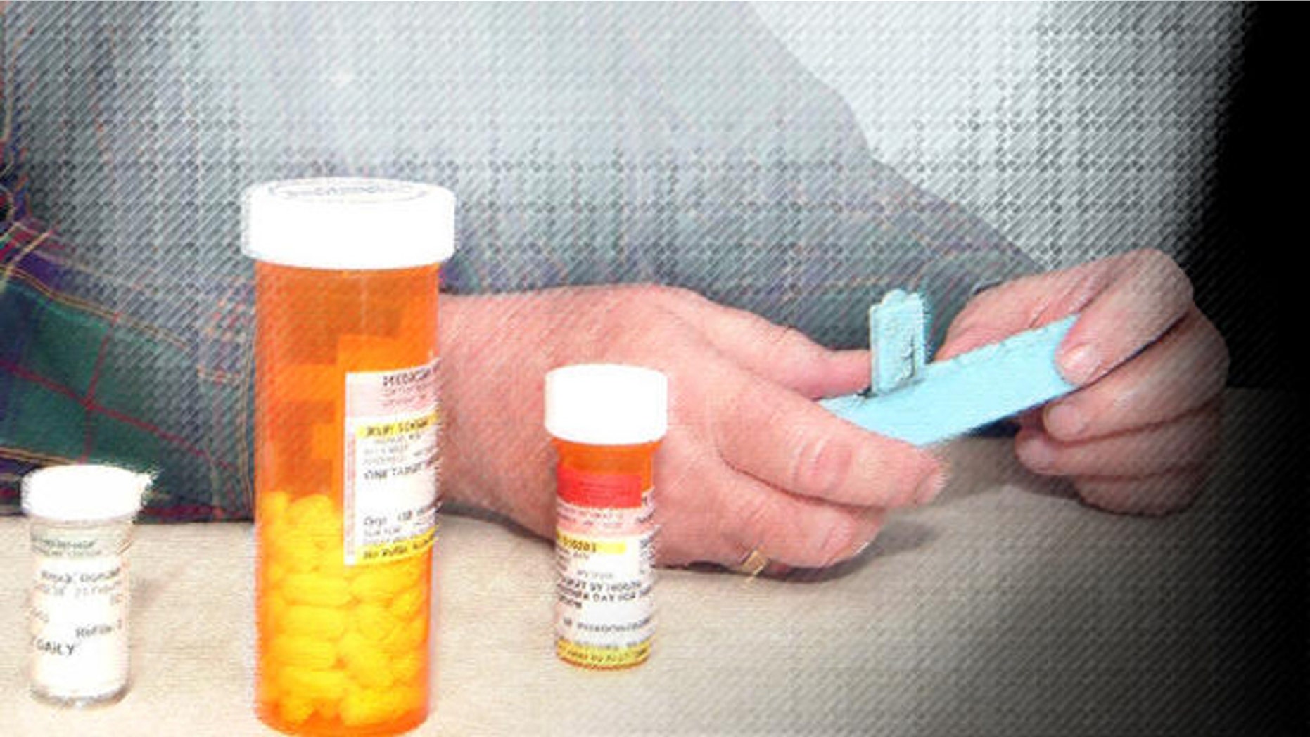 Don Brock of Litchfield, Minn., looks at some of his prescription drugs at his home in Litchfield, Minn. Friday, Feb. 10, 2006. Brock quit buying prescription drugs from Canada this year, now that he's signed up for the new federal Medicare drug benefit. (AP Photo/Bill Zimmer)