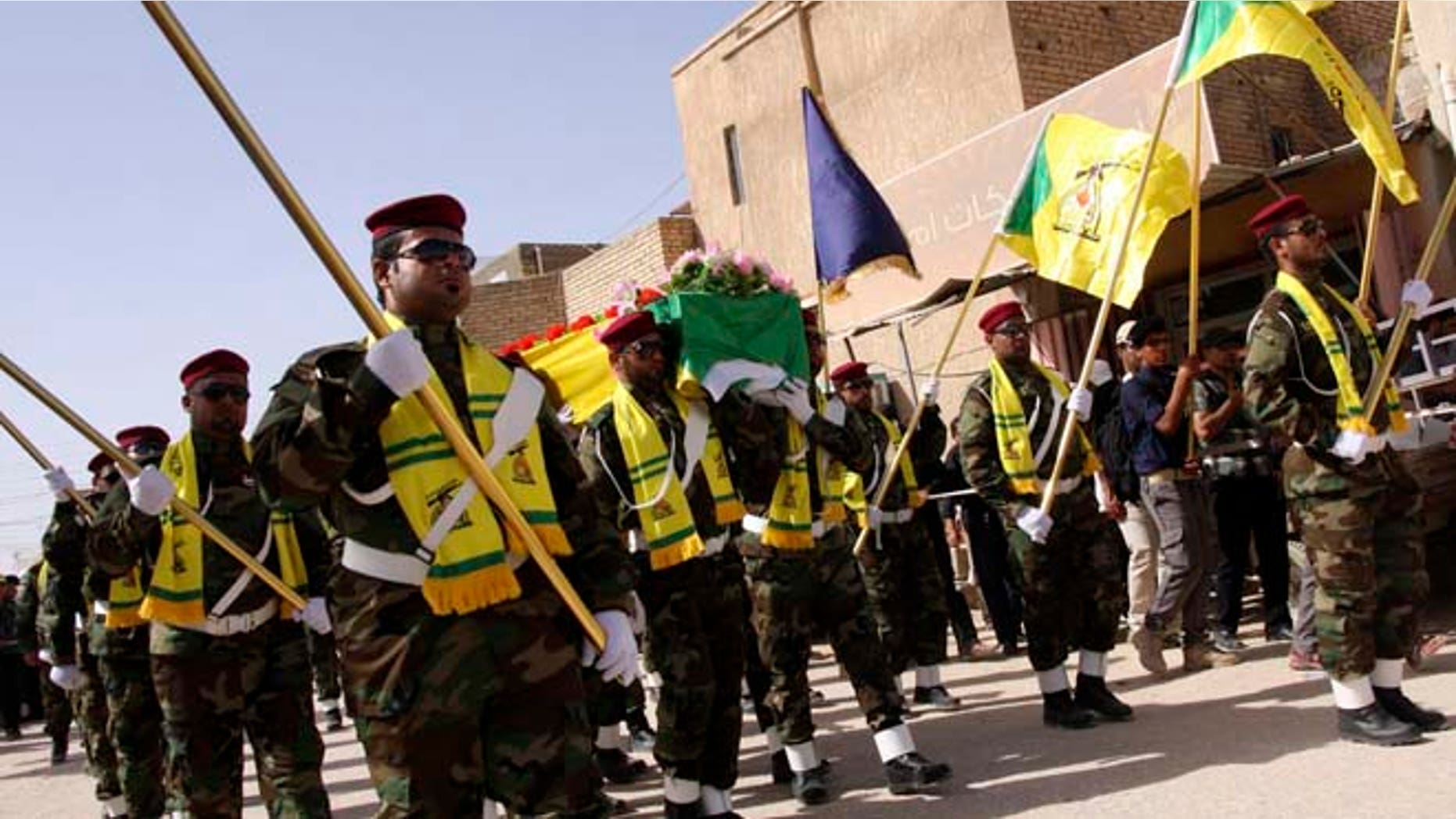 In this June 5, 2013 photos, members of Hezbollah Iraq march during a funeral in Kerbala, 70 miles south of Baghdad.