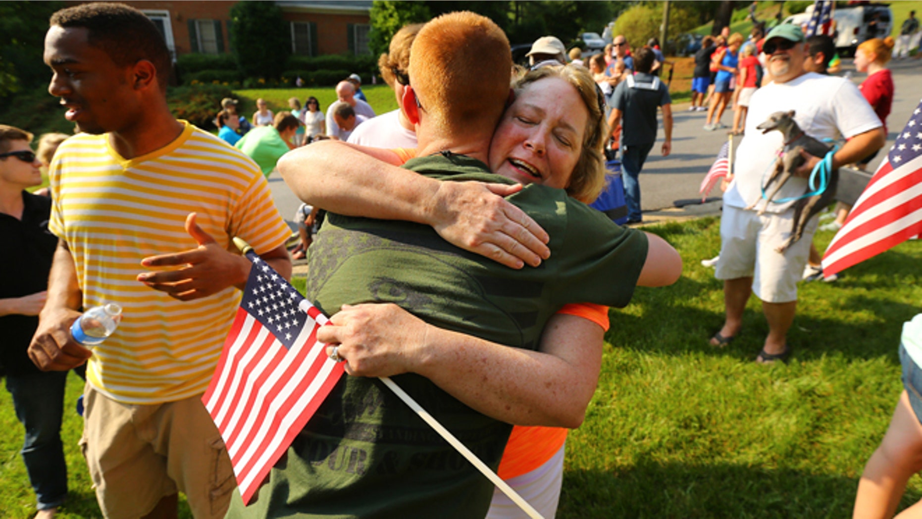 May 25, 2014: Neighbor Kathy Batton hugs Purple Heart recipient Lance Cpl. Alex Juedes, who was severely injured in Afghanistan in January of this year, as he gets a hero's welcome from friends, family and neighbors arriving home on the eve of Memorial Day in Marietta, Ga.