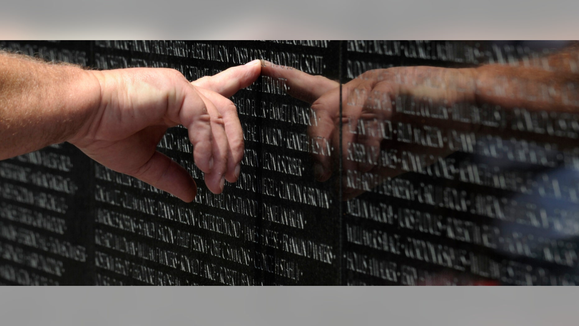 A visitor to the Vietnam Veteran's Memorial touches the name of a fallen soldier etched on the wall of the memorial in Washington, Friday, May 25, 2012. On Monday, the Vietnam Veterans Memorial Wall will begin the national commemoration of the Vietnam Warâs 50th anniversary. (AP Photo/Susan Walsh)