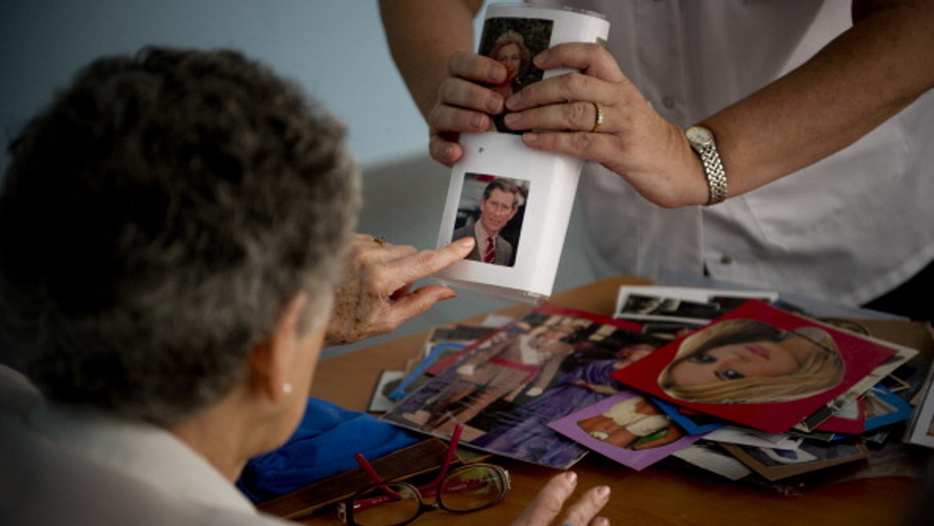 Social worker Nuria Casulleres shows a portrait to an elderly woman during a memory activity in Spain.