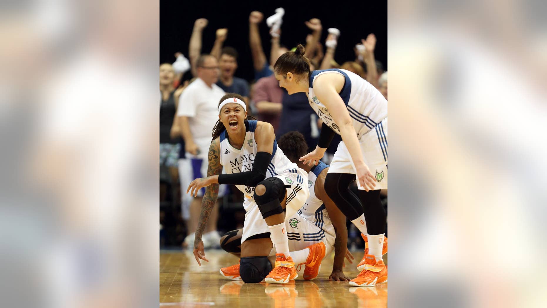 Minnesota Lynx guard Seimone Augustus, left, falls to the floor in celebration with teammate Lindsay Whalen, right, after tying up the score during the second half of Game 2 of the WNBA basketball Western Conference finals against the Phoenix Mercury, Sunday, Aug. 31, 2014, in Minneapolis. The Lynx won 82-77. (AP Photo/The Star Tribune, Kyndell Harkness) MANDATORY CREDIT; ST. PAUL PIONEER PRESS OUT; MAGAZINES OUT; TWIN CITIES LOCAL TELEVISION OUT