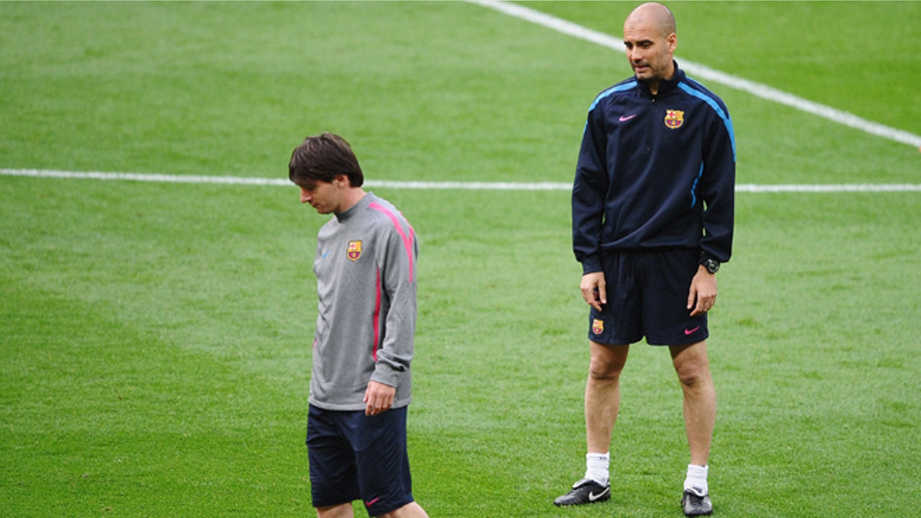 Lionel Messi of FC Barcelona (L) walks away from Josep "Pep" Guardiola, then-manager of FC Barcelona looks on during training session at Wembley Stadium in London on May 27, 2011. The two will face off in a game between Barca and Guardiola's new team, Bayern Munich. (Photo by Laurence Griffiths/Getty Images)