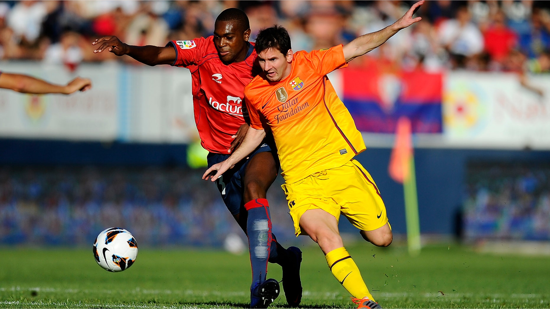 Lionel Messi of FC Barcelona (R) duels for the ball with Raoul Cedric 'Raoul Loe' of CA Osasuna during the La Liga match between CA Osasuna and FC Barcelona at Estadio Reyno de Navarra on August 26, 2012 in Pamplona, Spain. (Photo by David Ramos/Getty Images)