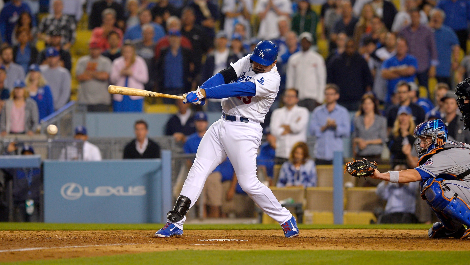 Los Angeles Dodgers' Adrian Gonzalez hits a game-winning RBI double as New York Mets catcher John Buck looks on during the 12th inning of their baseball game against the New York Mets, Wednesday, Aug. 14, 2013, in Los Angeles. (AP Photo/Mark J. Terrill)