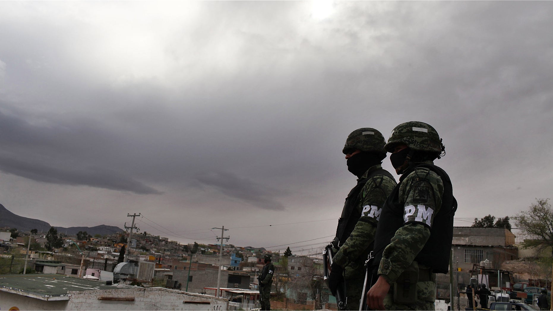 JUAREZ, MEXICO - MARCH 23: Military police stand guard at the scene of a murder on March 23, 2010 in Juarez, Mexico. Secretary of State Hillary Rodham Clinton, Defense Secretary Robert Gates, and Homeland Security Secretary Janet Napolitano all visited Mexico on today for discussions centered on Mexico's endemic drug-related violence. The border city of Juarez, Mexico has been racked by violent drug-related crime recently and has quickly become one of the most dangerous cities in the world in which to live. As drug cartels have been fighting over ever-lucrative drug corridors along the United States border, the murder rate in Juarez has risen to 173 slayings for every 100,000 residents. President Felipe Calderon's strategy of sending 7000 troops to Juarez has not mitigated the situation. With a population of 1.3 million, 2,600 people died in drug-related violence last year and 500 so far this year, including two Americans recently who worked for the U.S. Consulate and were killed as they returned from a child's party. (Photo by Spencer Platt/Getty Images)