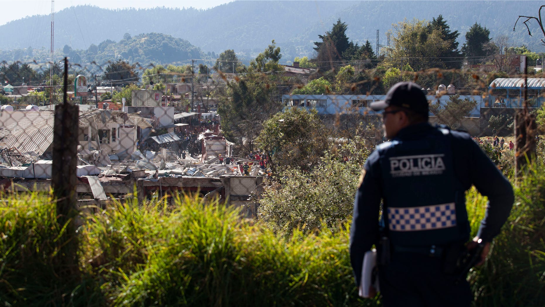 MEXICO CITY, MEXICO - JANUARY 29: A police officer stands guard as search and rescue workers inspect the rubble of an explosion at a children's hospital on January 29, 2015 in Mexico City, Mexico. Officials believe the explosion was caused by a leak from a gas truck. At least four people were killed and dozens injured. (Photo by Brett Gundlock/Getty Images)