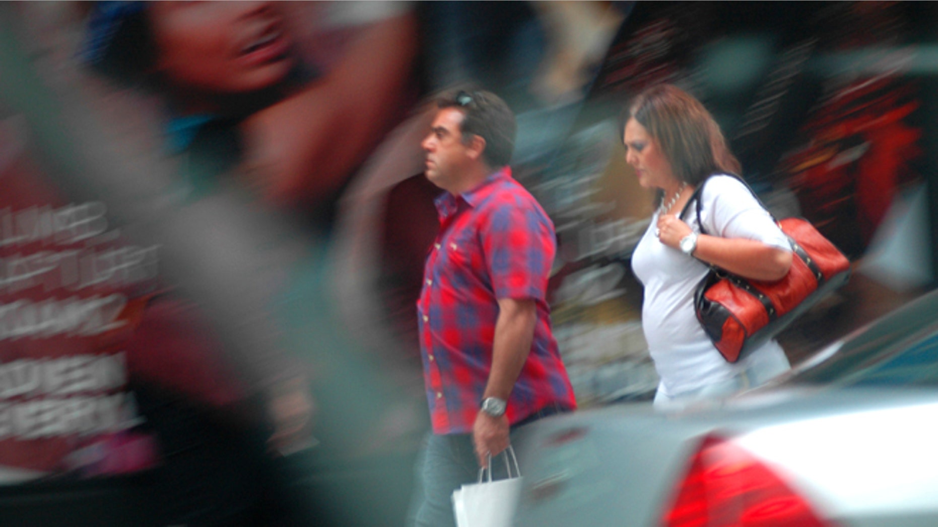 In this August 2013 surveillance photo provided by the Drug Enforcement Administration, Francisco Salgado and his sister Alejandra walk on New York's Third Avenue in midtown Manhattan where authorities say they made multiple cash deposits at banks within a few blocks of each other as part of a Mexican cartel money-laundering scheme. Authorities say the pair entered seven different banks making cash deposits of just under $10,000, all from piles of drug money they were carrying in designer purses and shopping bags. (DEA via AP)