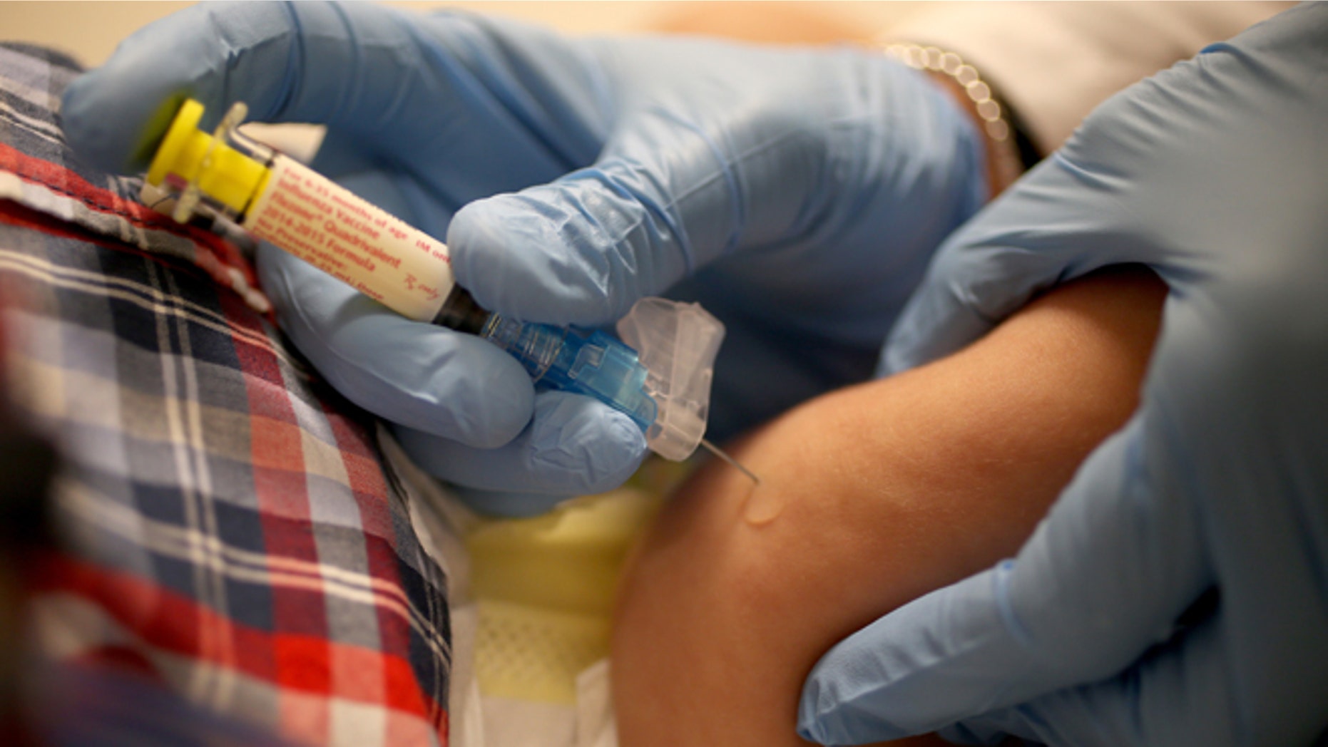 CORAL GABLES, FL - JANUARY 07: Pediatrician Dr. Amanda Porro M.D. delivers a flu vaccination to an infant's leg during his visit to the Miami Children's Hospital on January 7, 2015 in Coral Gables, Florida. The Centers for Disease Control and Prevention announced that in the United States the virus that causes the flu is particularly bad this year and has hit most parts of the United States, with 43 states experiencing "widespread" flu activity and six others reporting "regional" flu activity. (Photo by Joe Raedle/Getty Images)