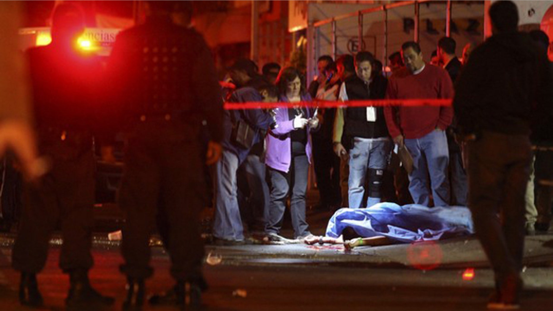 Feb. 12: Police officers and forensic workers stand near the covered-up body of a man outside a nightclub in an upscale neighborhood of Guadalajara. A group of hitmen showed up outside the club, started shooting and threw a grenade inside the building killing at least seven people and injuring another 30, according to local media (Reuters).