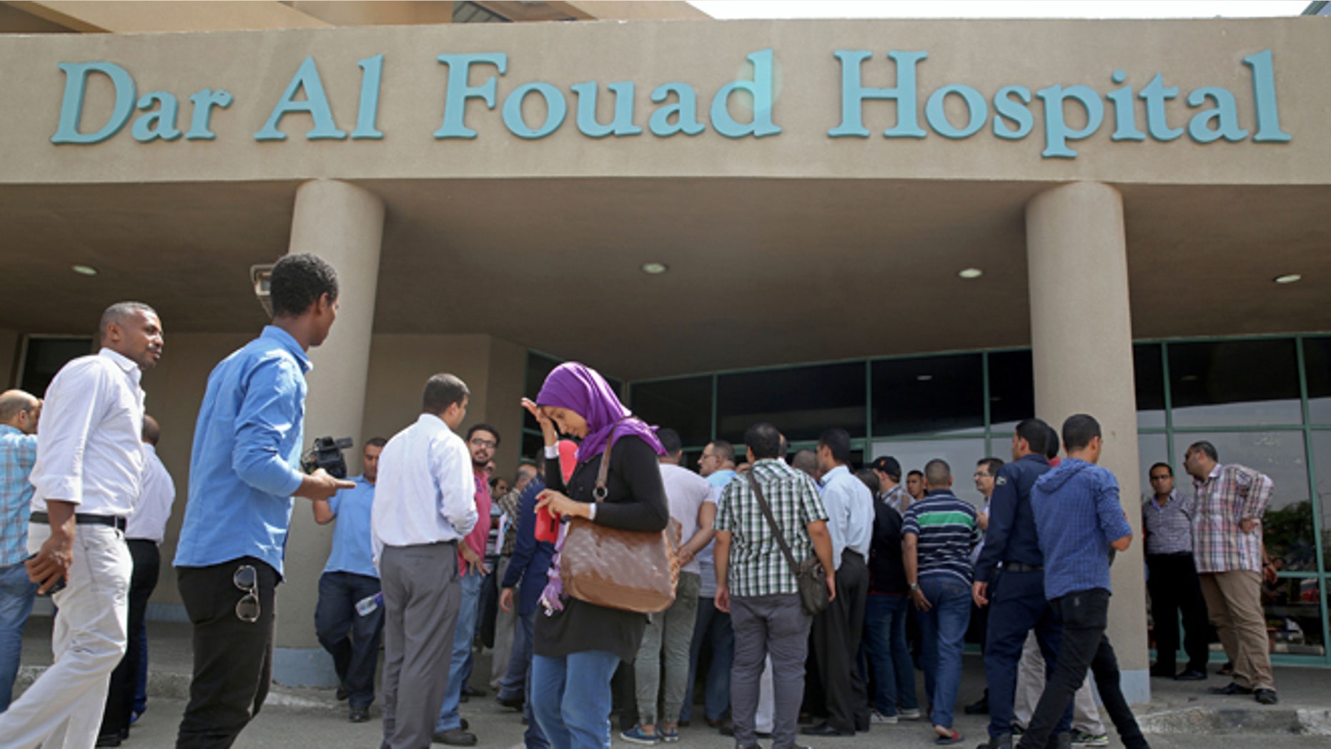 Egyptian journalists wait for information about tourists who were injured Sunday while on a desert safari trip, in front of the Dar Al Fouad Hospital in Cairo, Egypt, Monday, Sept. 14, 2015. At least 12 people were killed and 10 injured in Egypt's southwestern desert Sunday, Sept 13, 2015, when security forces mistakenly fired on a group of Mexican tourists, Egyptian officials said. The Mexican Foreign Ministry confirmed the incident and said at least two of the dead were Mexican nationals. (AP Photo/Nariman El-Mofty)
