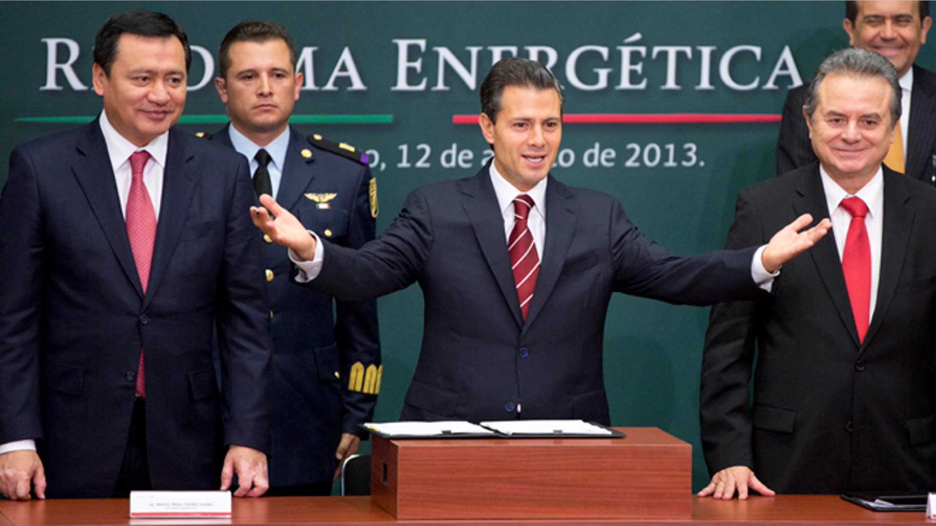 FILE - In this Aug. 12, 2013 file photo, Mexico's President Enrique Pena Nieto, center, greets the audience flanked by the Interior Secretary Miguel Angel Osorio Chong, left, and Energy Secretary Pedro Joaquin Coldwell during the ceremony to announce his proposal that would allow private firms to participate in the oil industry in Mexico City. Legislators from Mexicoâs two pro-energy reform political parties say they support constitutional changes to allow the government to grant licenses and share oil and profits with giants such as Exxon or Chevron. (AP Photo/Eduardo Verdugo, File)