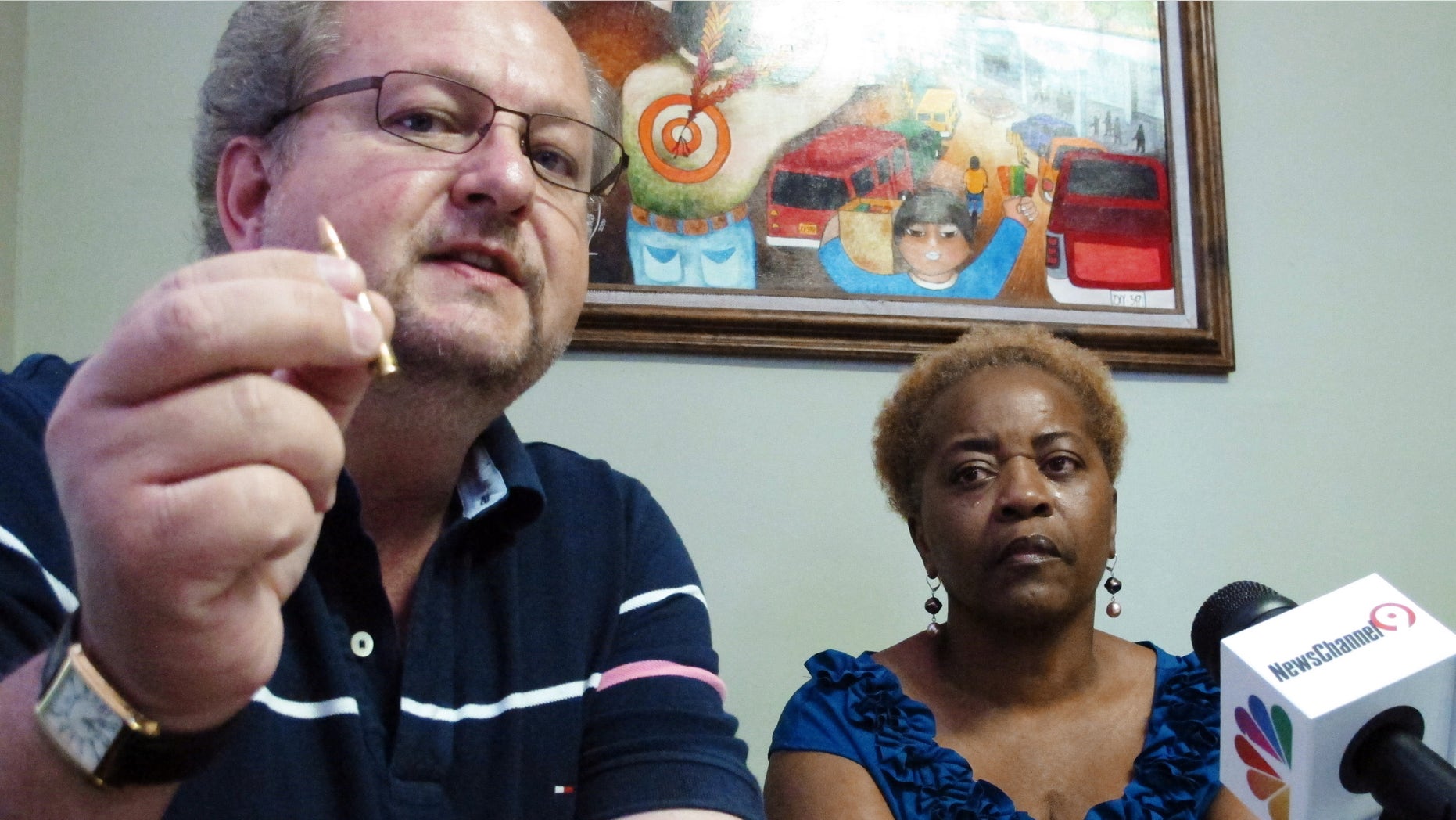 Kevin Huckabee, left, who also claims his son was wrongfully arrested in Mexico, holds a bullet as Aletha Smith, mother of trucker Jabin Bogan looks on during a news conference, Wednesday, May 2, 2012 in El Paso, Texas. Bogan, who was arrested with 268,000 bullets in Mexico, claims he took a wrong turn that led him into Mexico while transporting the cargo for an ammunition dealer in Arizona. (AP Photo/Juan Carlos Llorca)