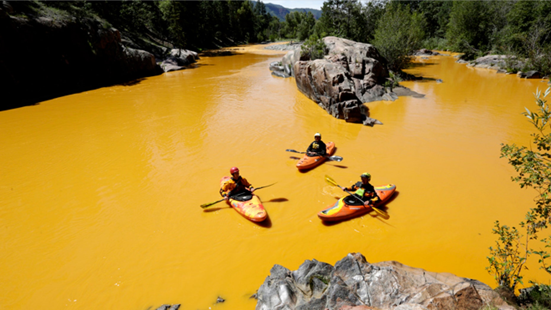 In this Thursday, Aug. 6, 2015 file photo, people kayak in the Animas River near Durango, Colo., in water colored yellow from a mine waste spill. A crew supervised by the U.S. Environmental Protection Agency has been blamed for causing the spill while attempting to clean up the area near the abandoned Gold King Mine. Tribal officials with the Navajo Nation declared an emergency on Monday, Aug. 10, as the massive plume of contaminated wastewater flowed down the San Juan River toward Lake Powell in Utah, which supplies much of the water to the Southwest. (Jerry McBride/The Durango Herald via AP, FILE)
