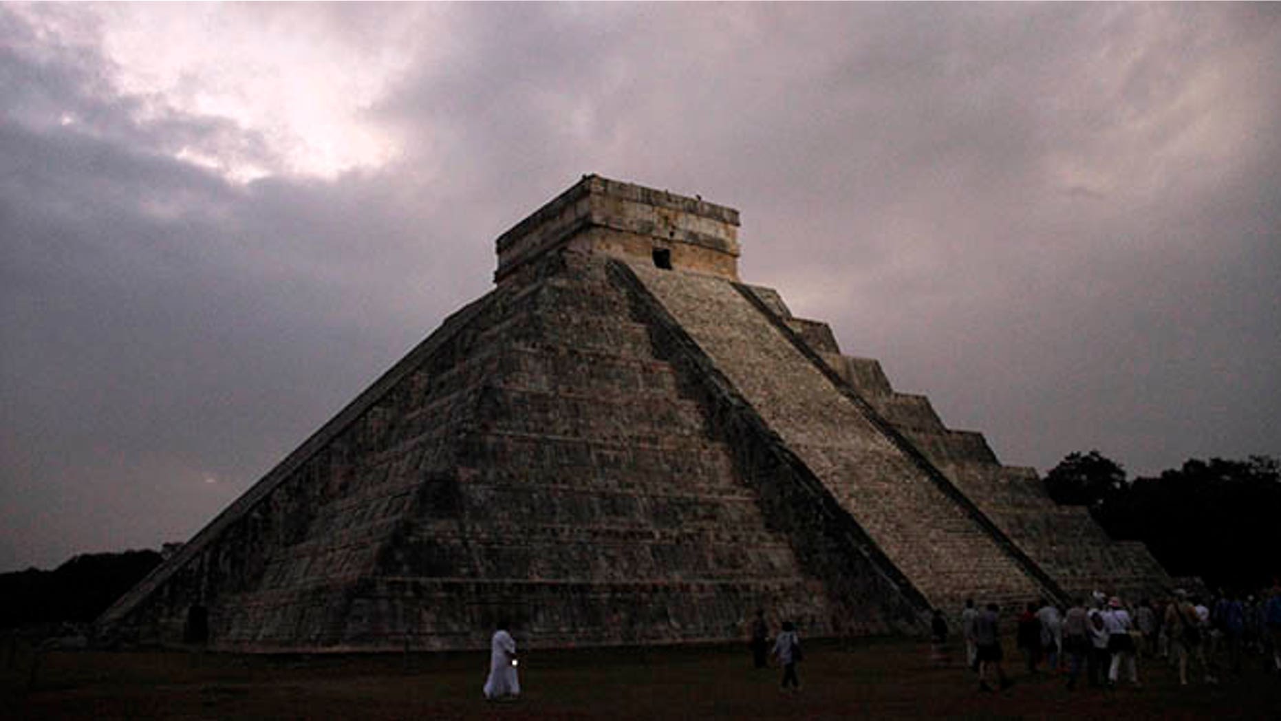 FILE - In this Dec. 21, 2012 file photo, people gather in front of the Kukulkan temple in Chichen Itza, Mexico. Mexican experts said Wednesday, Nov. 16, 2016 they have discovered what may be the original structure at the pyramid of Kukulkan at the Mayan ruins of Chichen Itza. (AP Photo/Israel Leal, File)