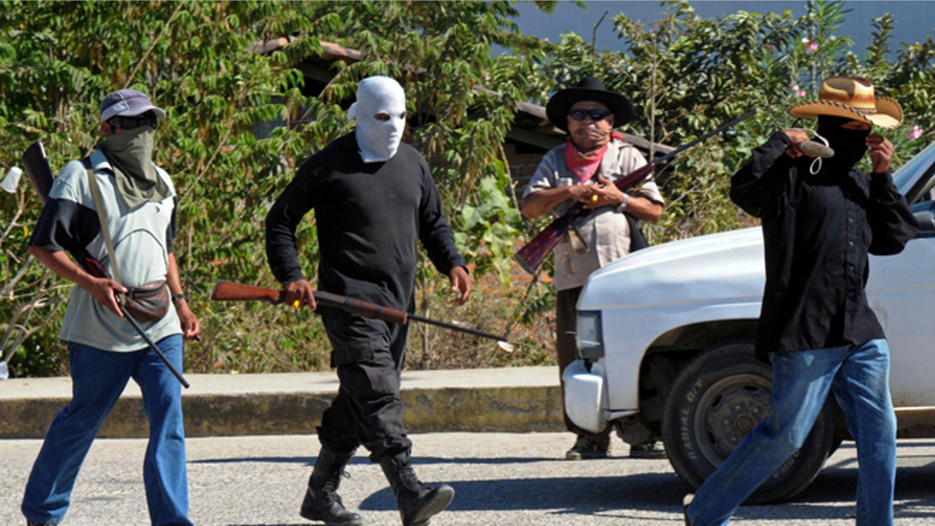 Civilians wearing ski masks or bandanas and carrying small arms, man a checkpoint in Teconoapa, in the Mexican state of Guerrero, Friday, Jan. 11, 2013. Several hundred civilians have taken up arms in two towns in the southwestern Mexico state and are arresting people suspected of crimes and imposing a curfew. Leaders said they were acting against crime and insecurity. Guerrero Gov. Angel Aguirre Rivero responded Friday by announcing that security in the region would be bolstered by sending in Mexican soldiers and marines and federal and state police officers. (AP Photo/Bernandino Hernandez)