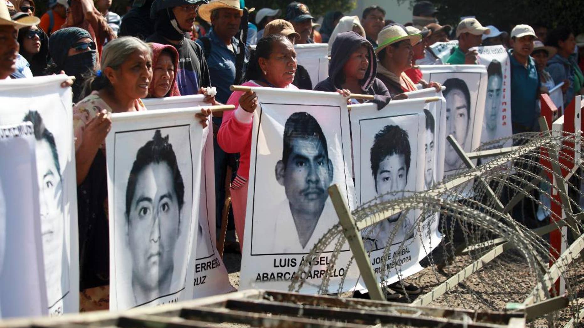 FILE - In this Dec. 18, 2014 file photo, relatives of missing students protest in front of the entrance to the 27th Infantry Battalion base in Iguala, Mexico. Mexican authorities announced Tuesday, Jan. 13, 2015, that the parents of the 43 missing students can enter army bases to search for their sons, but say there is no evidence the army was involved in their disappearance. (AP Photo/Felix Marquez, File)