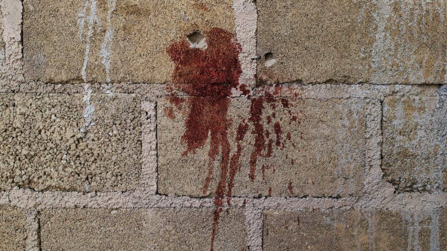 FILE - This July 3, 2014 file photo shows bullet holes and splattered blood on the wall of an an unfinished warehouse, where bodies of suspected criminals were found after an alleged gun battle with soldiers, on the outskirts of San Pedro Limon in Mexico state, Mexico. A Mexican human rights group released documents Thursday, July 2, 2015, that show high-ranking officers had given soldiers standing orders to “kill criminals” ahead of last year’s army slaying of the suspected criminals. The army opened a criminal investigation the same day of the incident, yet issued a press release saying the suspected criminals had died in a gun battle. (AP Photo/Rebecca Blackwell, File)
