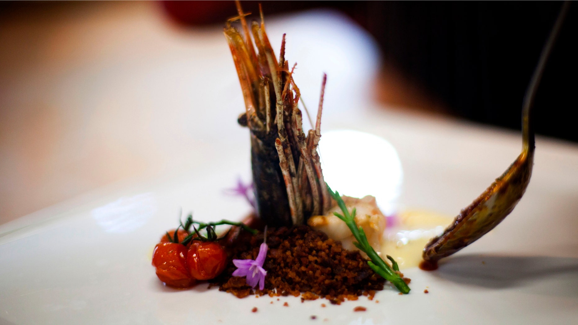 A chef prepares a reinterpretation of a dish served 50 years ago in Tijuana made of shrimp, marlin, tomato, onion, salicornia, cheese sauce and olive oil at the restaurant Mission 19 in Tijuana, Mexico. (AP Photo/Alex Cossio)