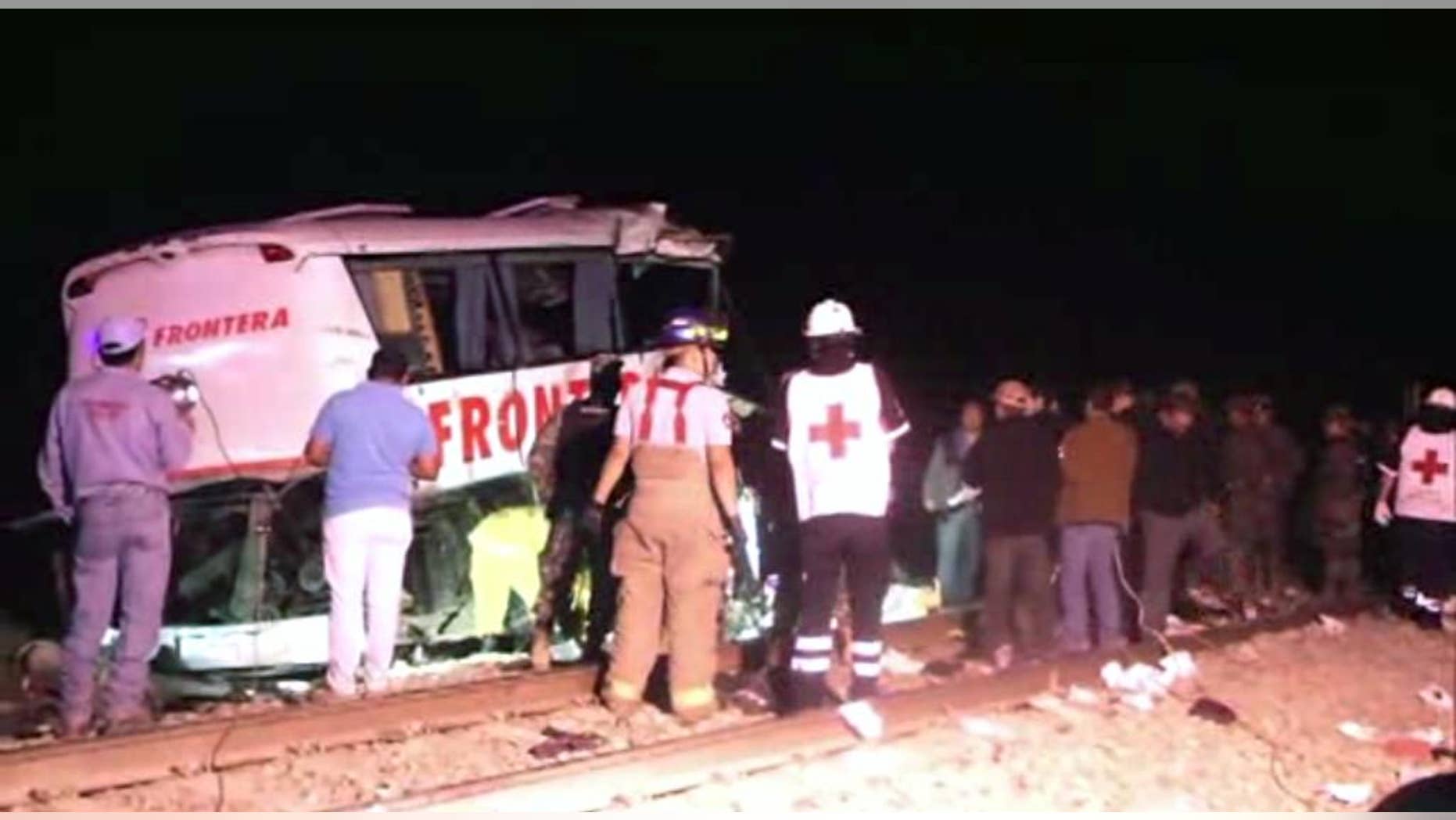 In this image made from Associated Press Television News video emergency responders work at the scene of a bus and freight train collision Friday Feb. 13, 2015. The collision at a grade crossing in northern Mexico, killed at least 16 people and injured 22, according to a Mexican official. The official said the accident Friday occured in the town of Anahuac, which is Tamaulipas state near the border city of Nuevo Laredo, across from Laredo, Texas. (AP Photo/AP Television)