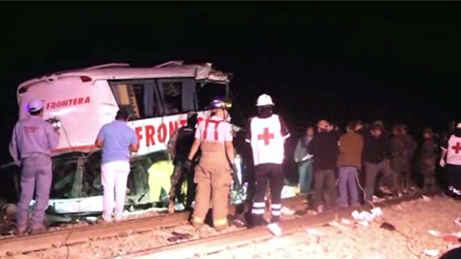 In this image made from Associated Press Television News video emergency responders work at the scene of a bus and freight train collision Friday Feb. 13, 2015. The collision at a grade crossing in northern Mexico, killed at least 16 people and injured 22, according to a Mexican official. The official said the accident Friday occured in the town of Anahuac, which is Tamaulipas state near the border city of Nuevo Laredo, across from Laredo, Texas. (AP Photo/AP Television)