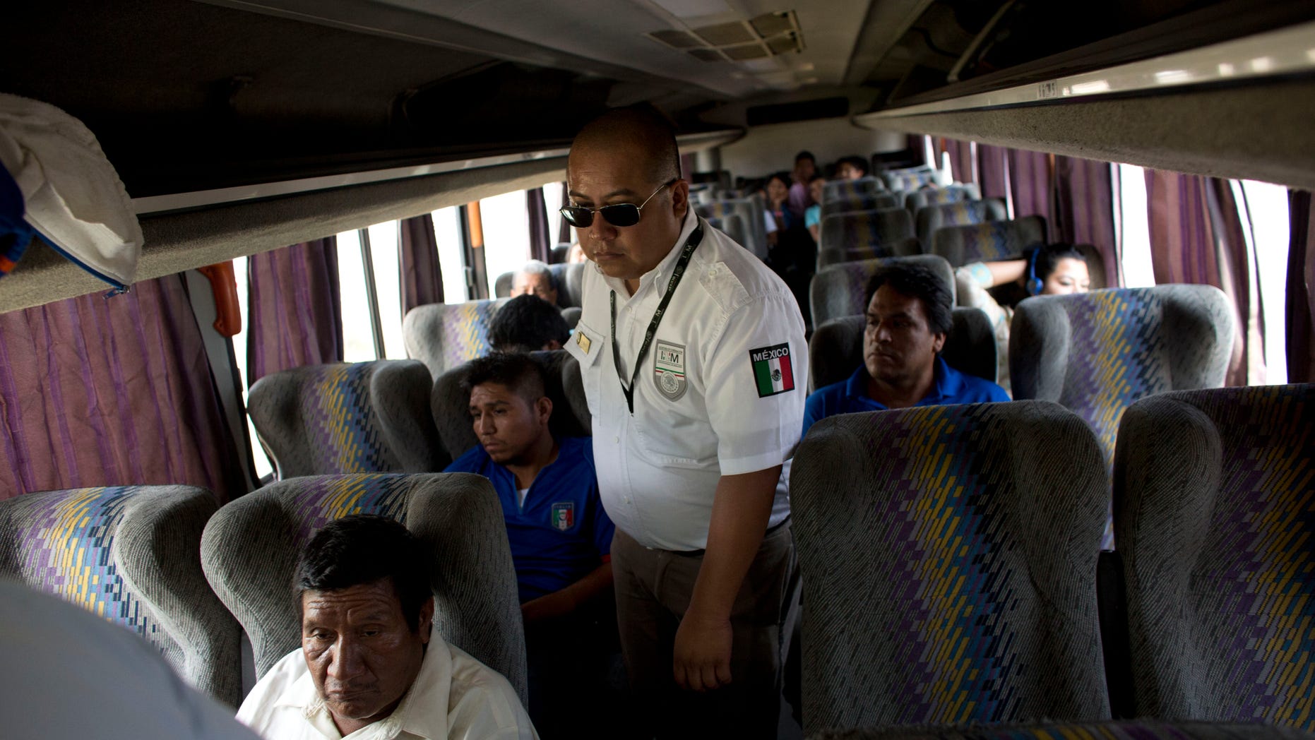 FILE - In this Aug. 27, 2014, file photo, an immigration official checks a bus for Central American migrants, at a roadblock north of Arriaga, Chiapas state, Mexico. According to data from Mexicos National Immigration Institute, Mexico has deported 79 percent more Central Americans in the first four months of 2015 than it did during the same period a year earlier. (AP Photo/Rebecca Blackwell, File)