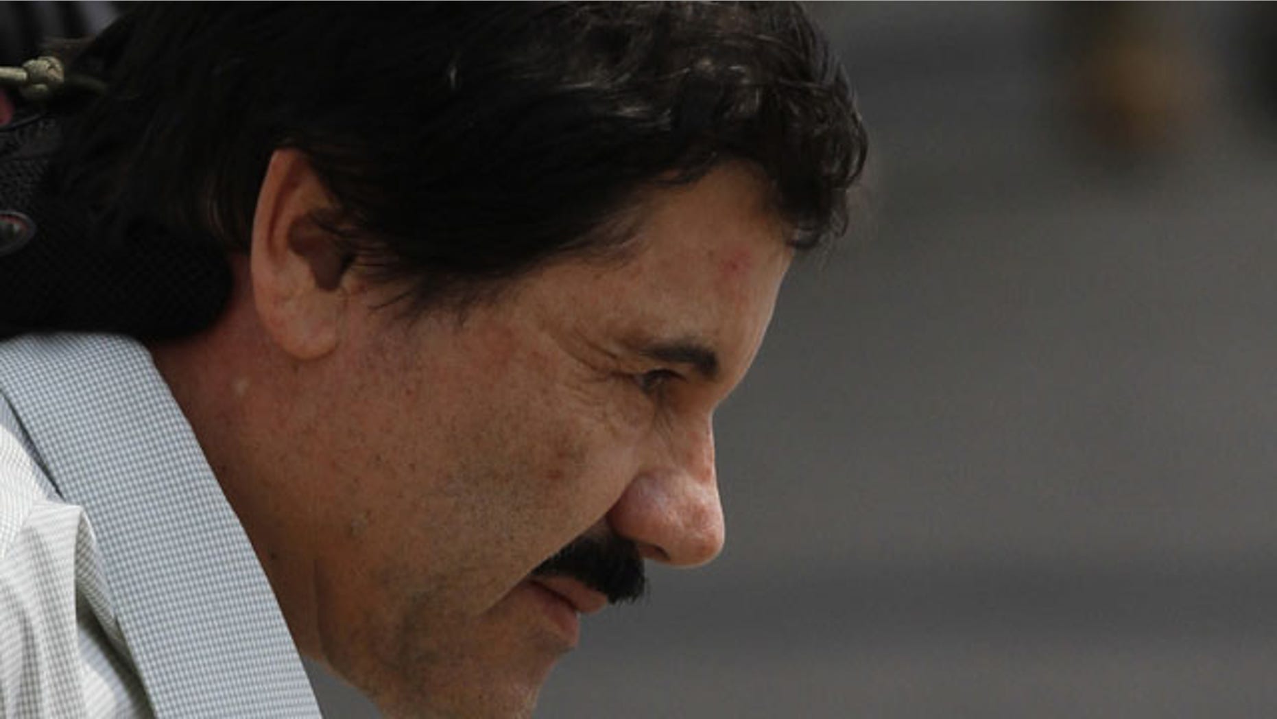 February 22, 2014: Joaquin "El Chapo" Guzman is escorted to a helicopter in handcuffs by Mexican navy marines at a navy hanger in Mexico City. (AP Photo/Marco Ugarte)