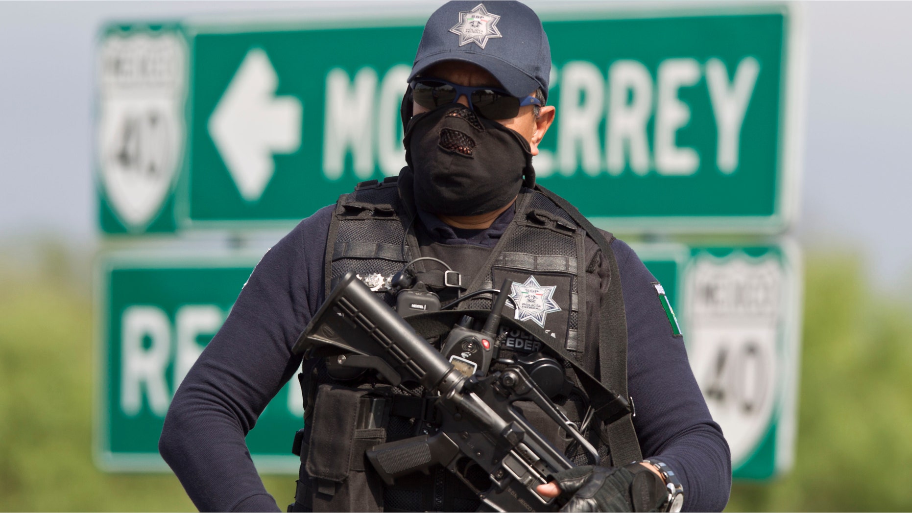 A federal policeman guards the area where dozens of bodies, some of them mutilated, were found on a highway connecting the northern Mexican metropolis of Monterrey to the U.S. border found in the town of San Juan near the city of Monterrey, Mexico, Sunday, May 13, 2012. (AP Photo/Christian Palma)