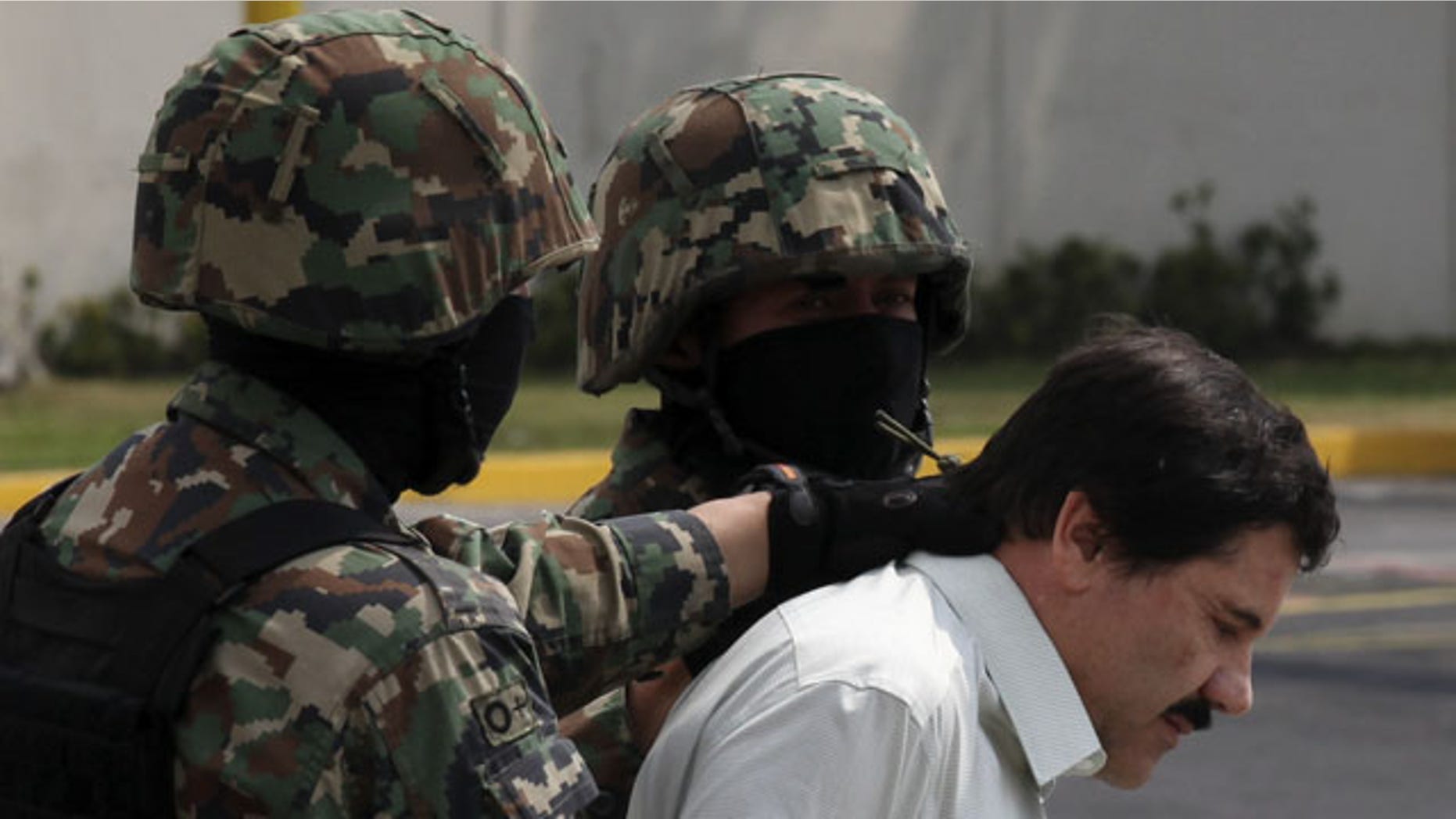FILE - In this Feb. 22, 2014, file photo, Joaquin "El Chapo" Guzman, in handcuffs, is escorted to a helicopter by Mexican navy marines in Mexico City, Mexico. (AP)