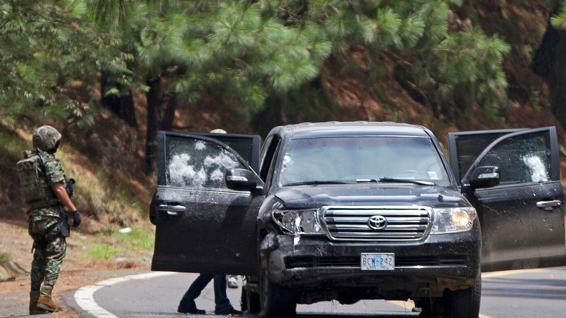 This Aug. 24, 2012, photo shows the armored U.S. embassy vehicle being checked by military personal after it was attacked by unknown assailants on the highway leading to the city of Cuernavaca, Mexico.