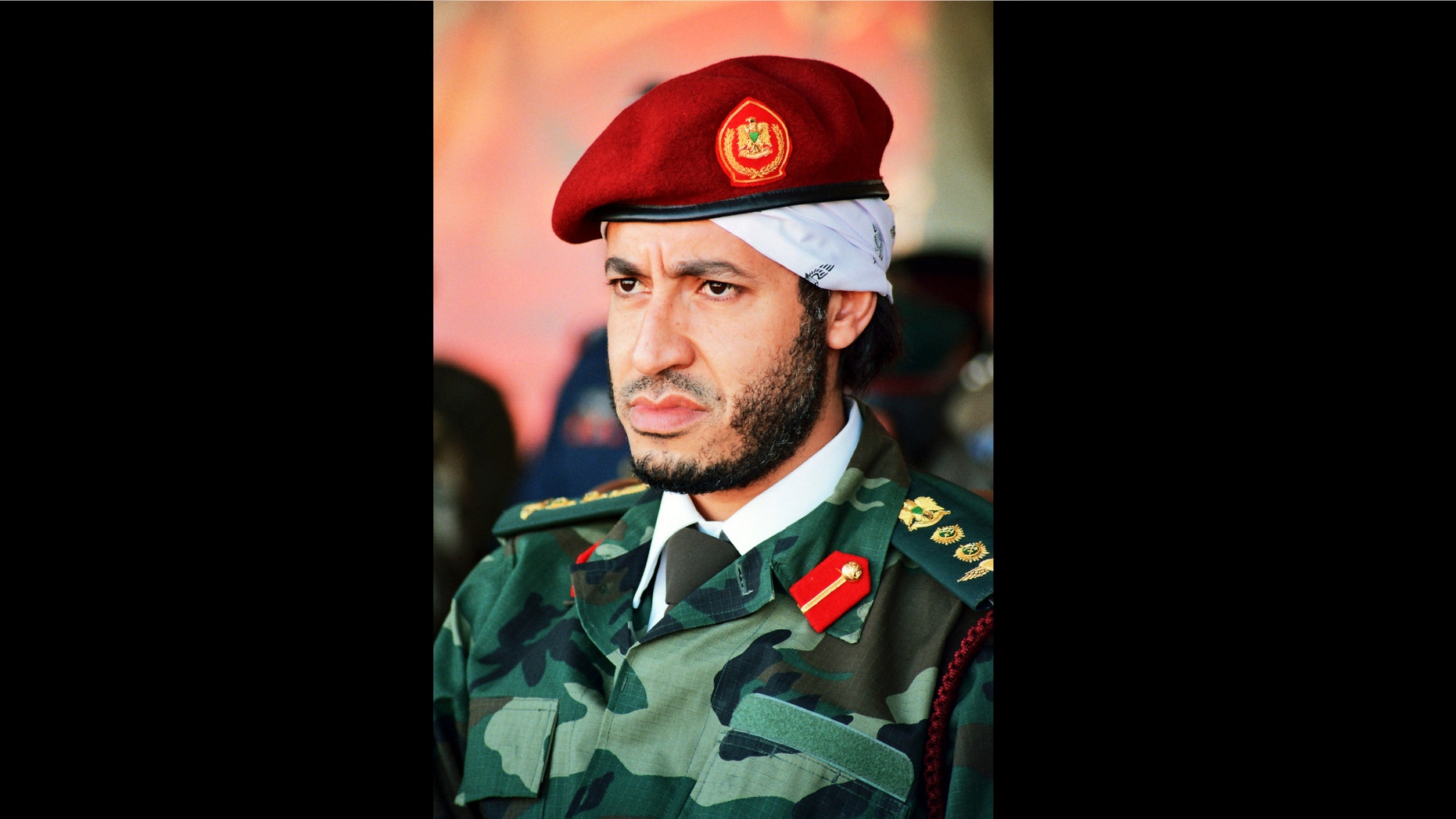 FILE - In this undated file photo made available on Sunday Sept. 25, 2011, al-Saadi Gadhafi, son of the late Libyan leader Moammar Gadhafi, watches a military exercise by the elite military unit commanded by his brother, Khamis, in Zlitan, Libya. Mexican prosecutors say they broke up not one, but two Indiana Jones-style plots to "extract" the son of late Libyan dictator Moammar Gadhafi from Libya as his father's regime crumbled. Mexico's Assistant Attorney General Jose Cuitlahuac Salinas says the plan to bring al-Saadi Gadhafi to Mexico involved piles of stolen passports, white-knuckle flights with pilots who refused to land in war-torn Libya and luxury homes bought under false names in Mexico. (AP Photo/Abdel Magid al-Fergany, File)