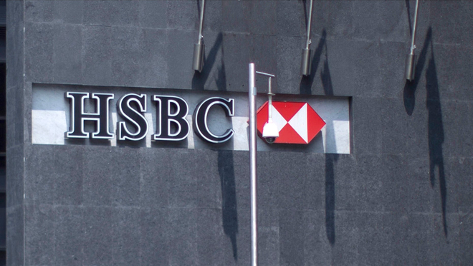 A woman walks in front of the HSBC bank headquarters in Mexico City, Tuesday, July 17, 2012. The chief compliance officer of Britain's HSBC Tuesday said he was stepping down from that position after an investigation found that lax controls at the international bank allowed Mexican drug cartels to launder billions of dollars through its U.S. operation and other illicit transactions. (AP Photo/Alexandre Meneghini)