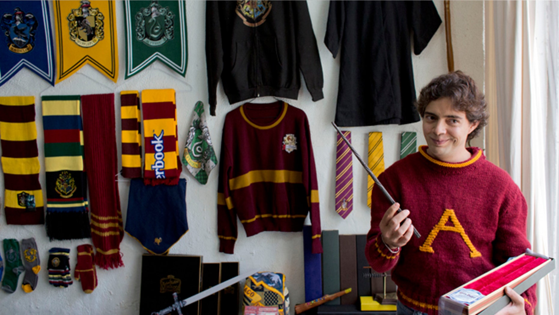 Menahem Asher Silva Vargas a 37 year old lawyer, displays a favorite wand, as he shows off his collection of Harry Potter memorabilia after being awarded the Guinness World Record title for the largest collection, in Mexico City, Monday, Sept. 29, 2014. Silva's collection consists of more than 3000 individual items, including figurines, trading cards, wands, clothing, and accessories.(AP Photo/Rebecca Blackwell)