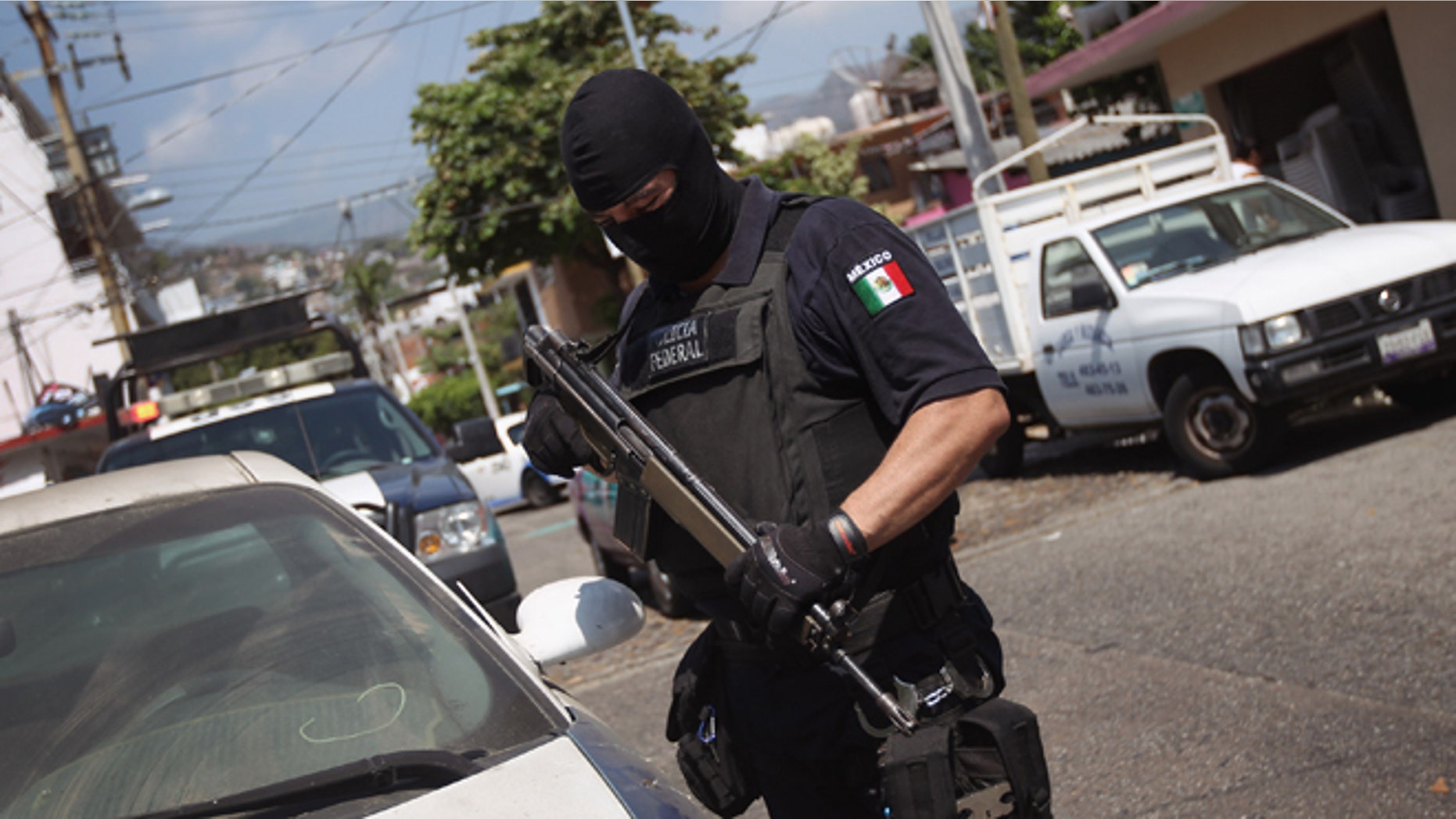 ACAPULCO, MEXICO - MARCH 01: A Mexican federal policeman inspects an abandoned car on March 1, 2012 in Acapulco, Mexico. Stolen vehicles used by drug gangs are often found abandoned throughout the city. Drug violence surged in the coastal resort last year, making Acapulco the second most deadly city in Mexico after Juarez. One of Mexico's top tourist destinations, Acapulco has suffered a drop in business, especially from foreign tourists, due to reports of the violence. Toursim accounts for some 9 percent of Mexico's economy and about 70 percent of the output of Acapulco's state of Guerrero. (Photo by John Moore/Getty Images)