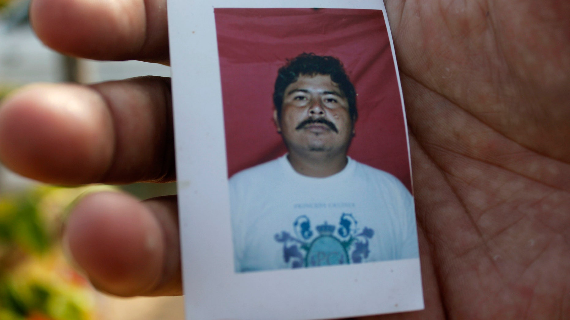 A relative of journalist Gregorio Jimenez holds a photo of him in Coatzacoalcos, Mexico.