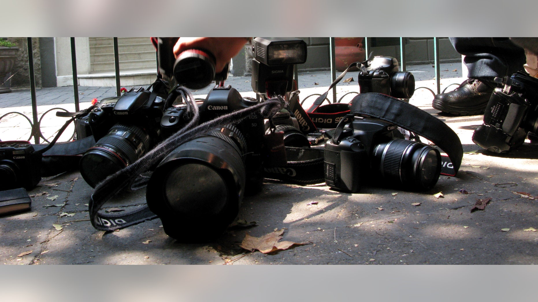 Photojournalists place their cameras on the floor during a demonstration condemning the alleged murder of fellow journalist Regina Martinez in Mexico City, Sunday April 29, 2012. The Mexican government's human rights commission said Sunday that it will investigate the apparent slaying of a correspondent for Proceso newsmagazine who often wrote about drug trafficking. Police found the body of Martinez on Saturday inside the bathroom of her home in the Veracruz state capital, Xalapa. (AP Photo/Marco Ugarte)